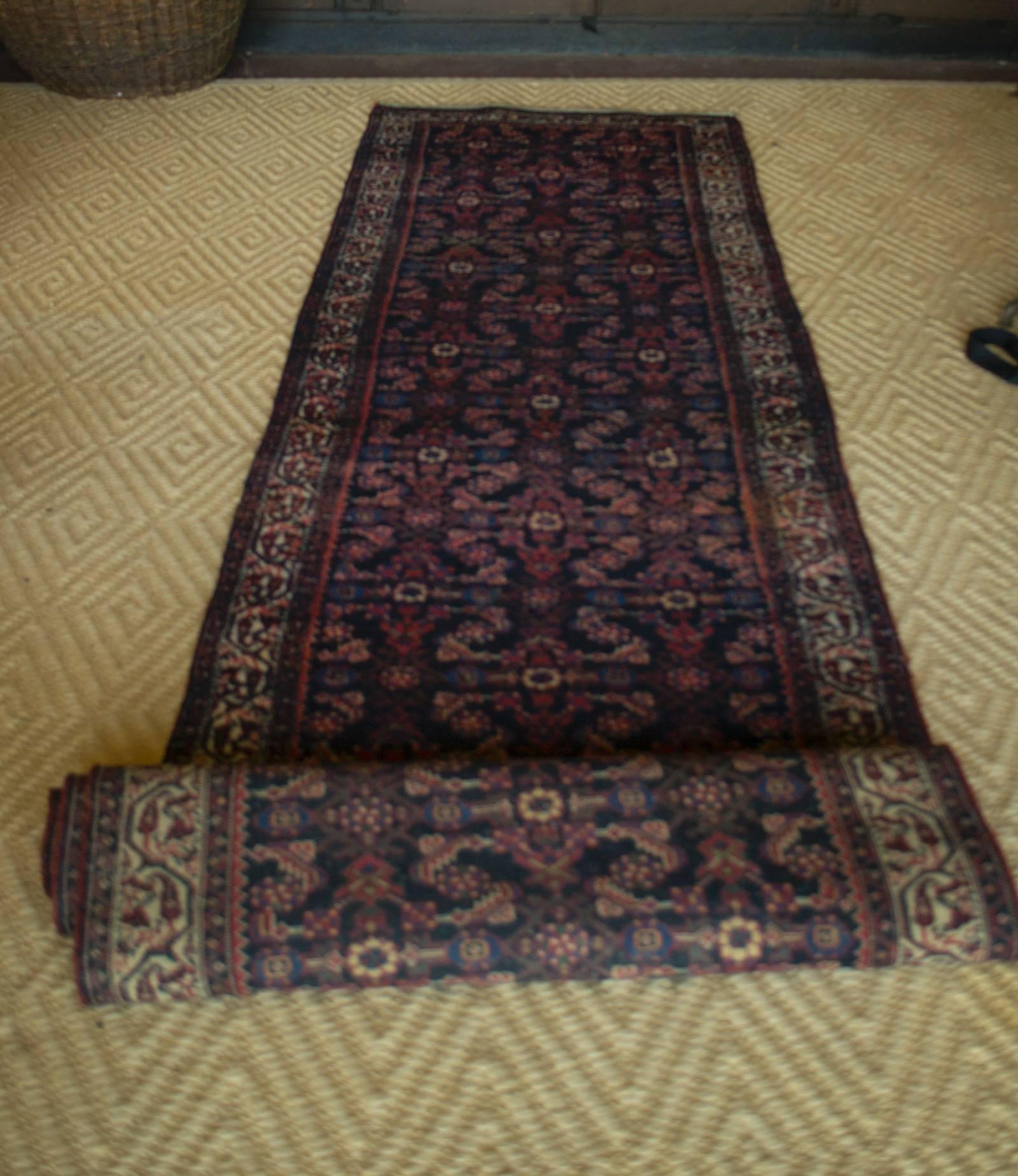 Vintage Afghan rug runner with red, blue, green, and cream interlocking motif.