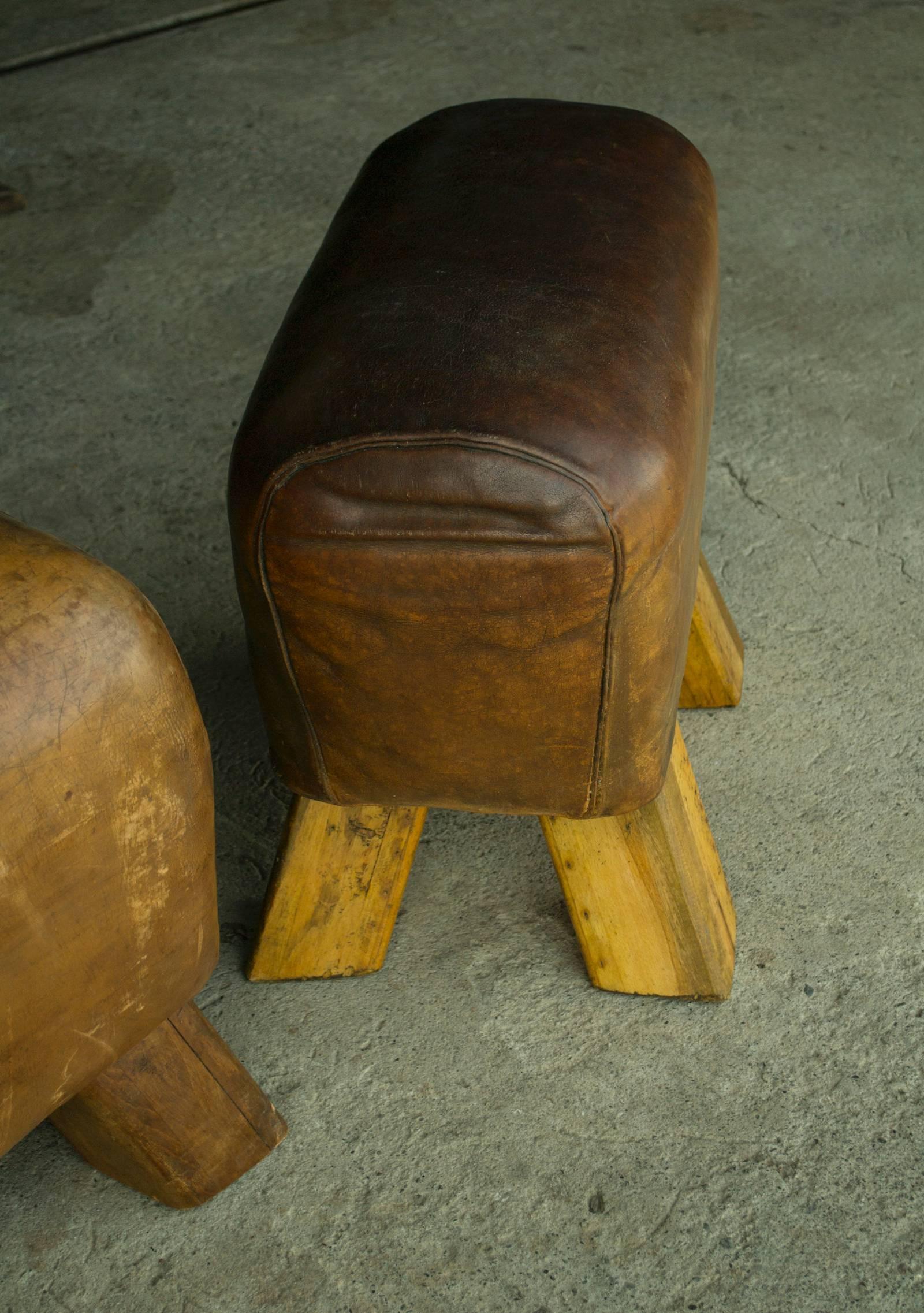 Piggy on the Left with darker legs is Available.*

Leather gym bench piggies with wooden legs.

Priced individually; each bench unique, please inquire for specific dimensions.