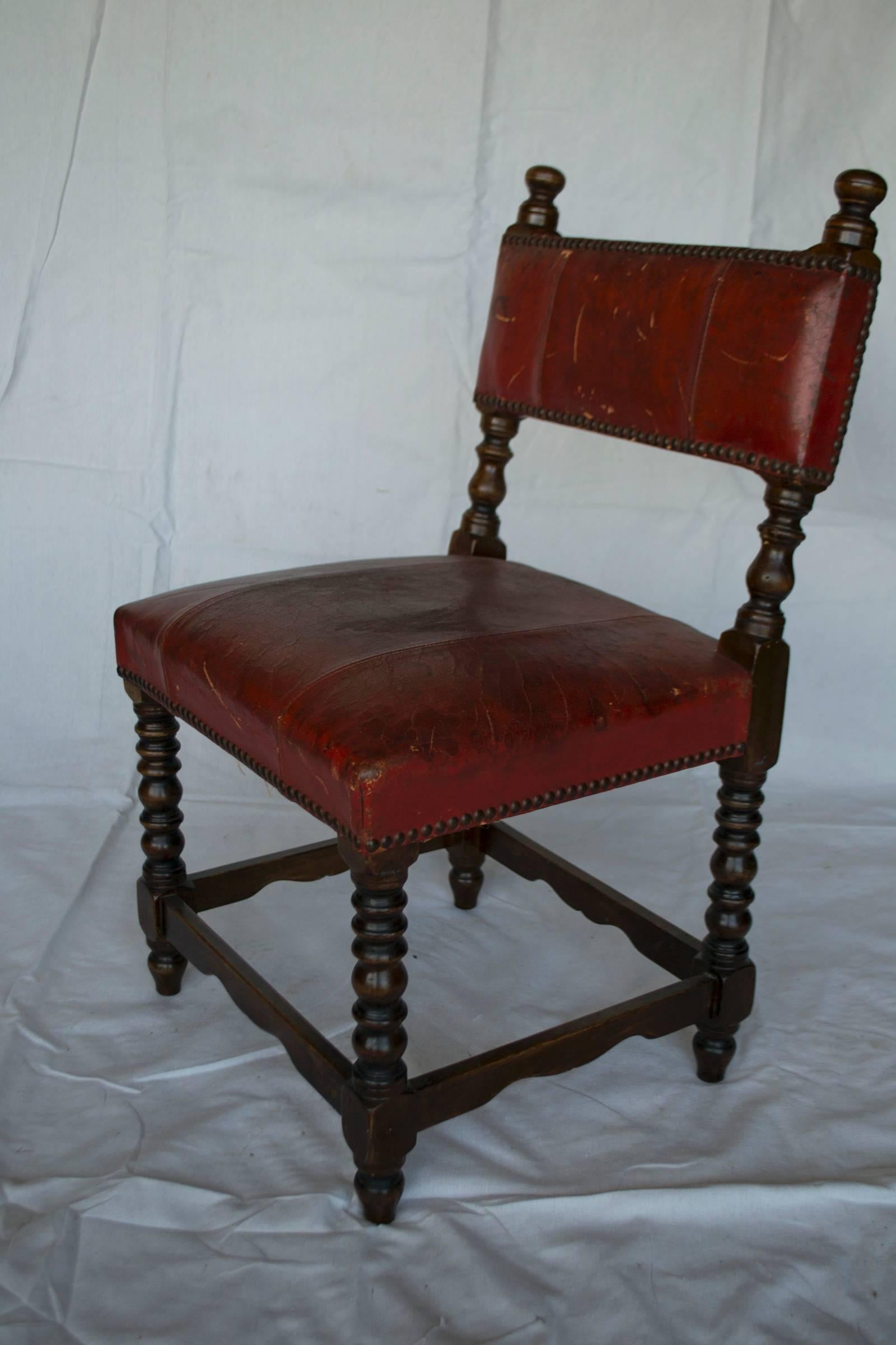 Vintage child's chair, circa 19th century. Wood frame with nailed red/brown leather seat and back.