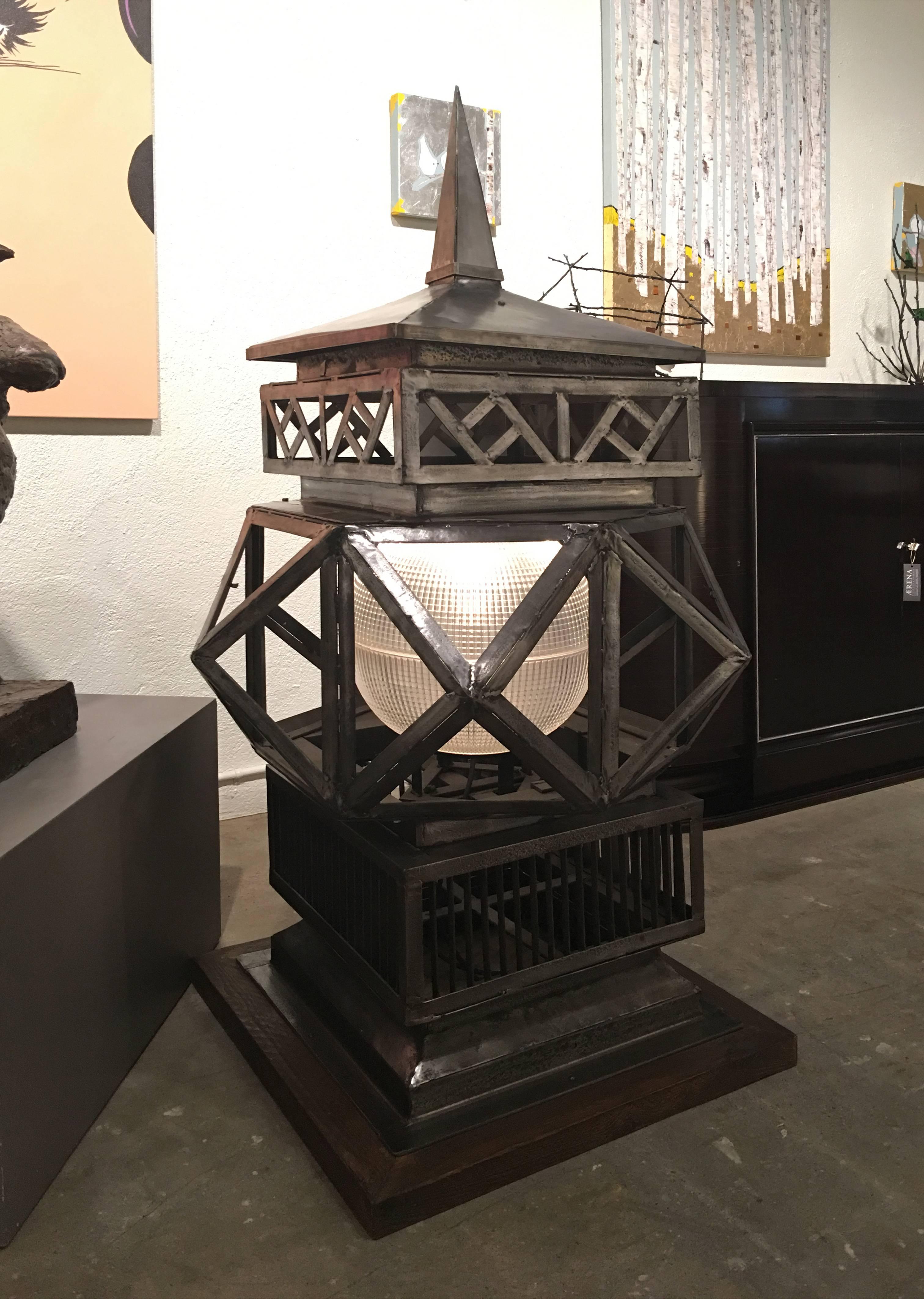 Pair of monumental welded geometric metal lanterns acquired in London. 

Each are welded metal on a wood base; glass lantern orbs were a later addition. Origins unknown; likely plinth lights part of a casino, hotel, or club etc.
