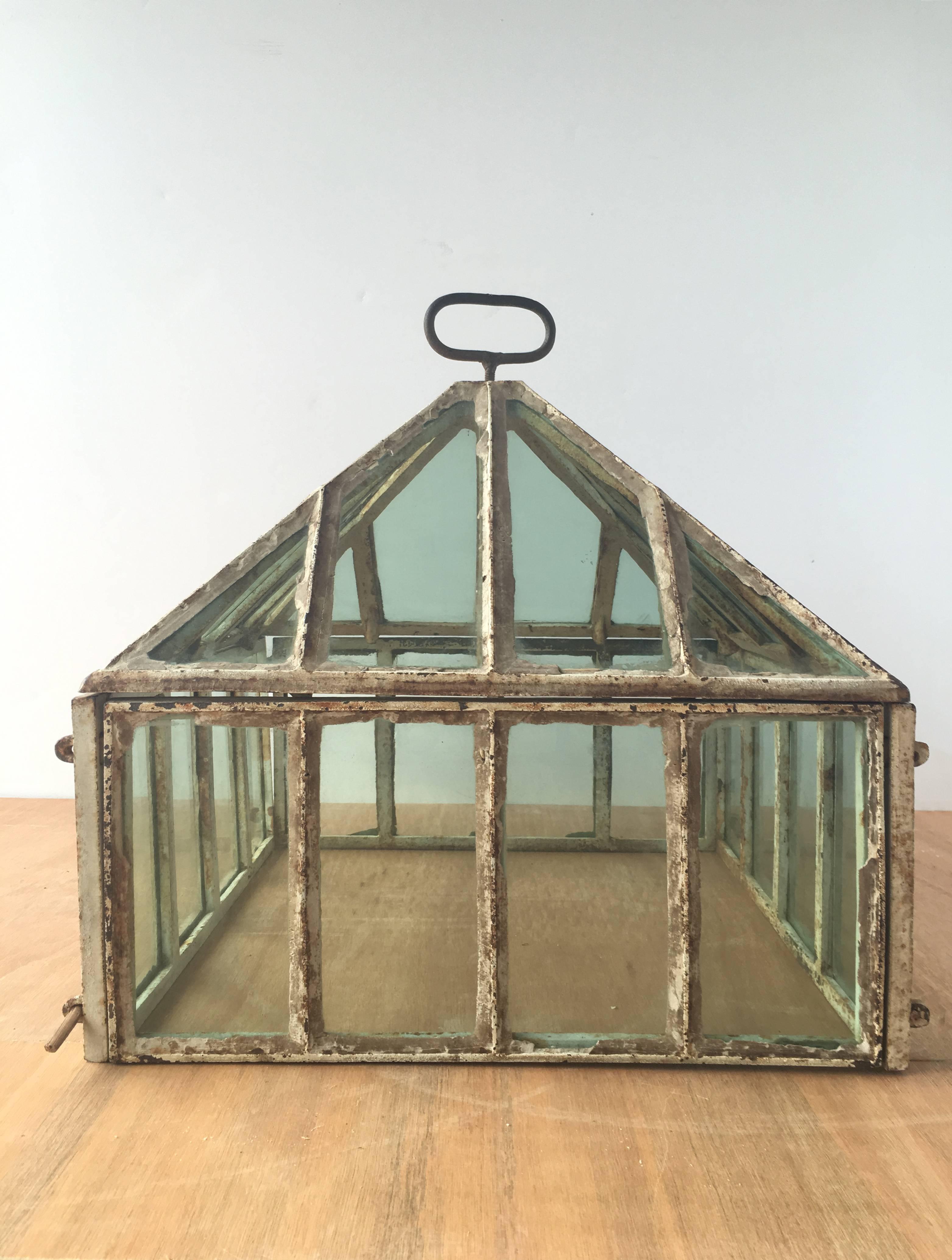 Vintage English iron and green glass cold frame greenhouse, circa 1860. 

Historically also known as a cucumber frame in the Victorian era; the lid lifts off with the handle, and sides close with wooden pegs. 

Can be use decoratively indoors or in