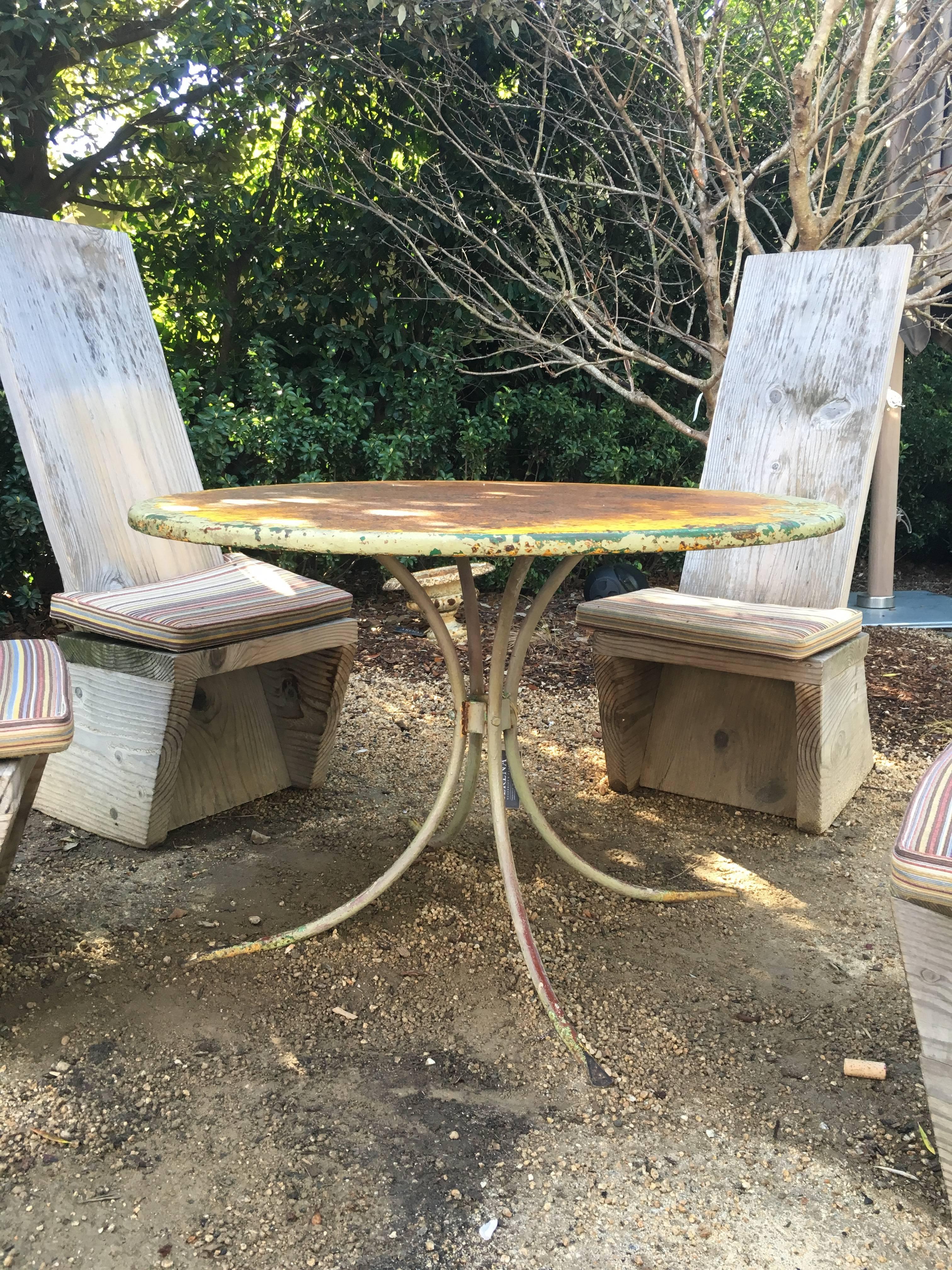 Vintage green garden table, American, circa 1940. Surface patina with multiple layers of paint revealed, including pale and dark green and warm yellow. Minor wear consistent with age and use.
