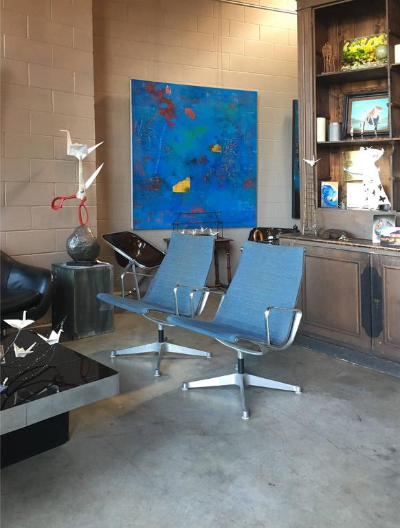 Vintage aluminium Eames Group armchairs with original blue Alexander Girard hopsack upholstery.

Priced for grouping of 4.8 total available in sets of two; please inquire for a specific grouping.