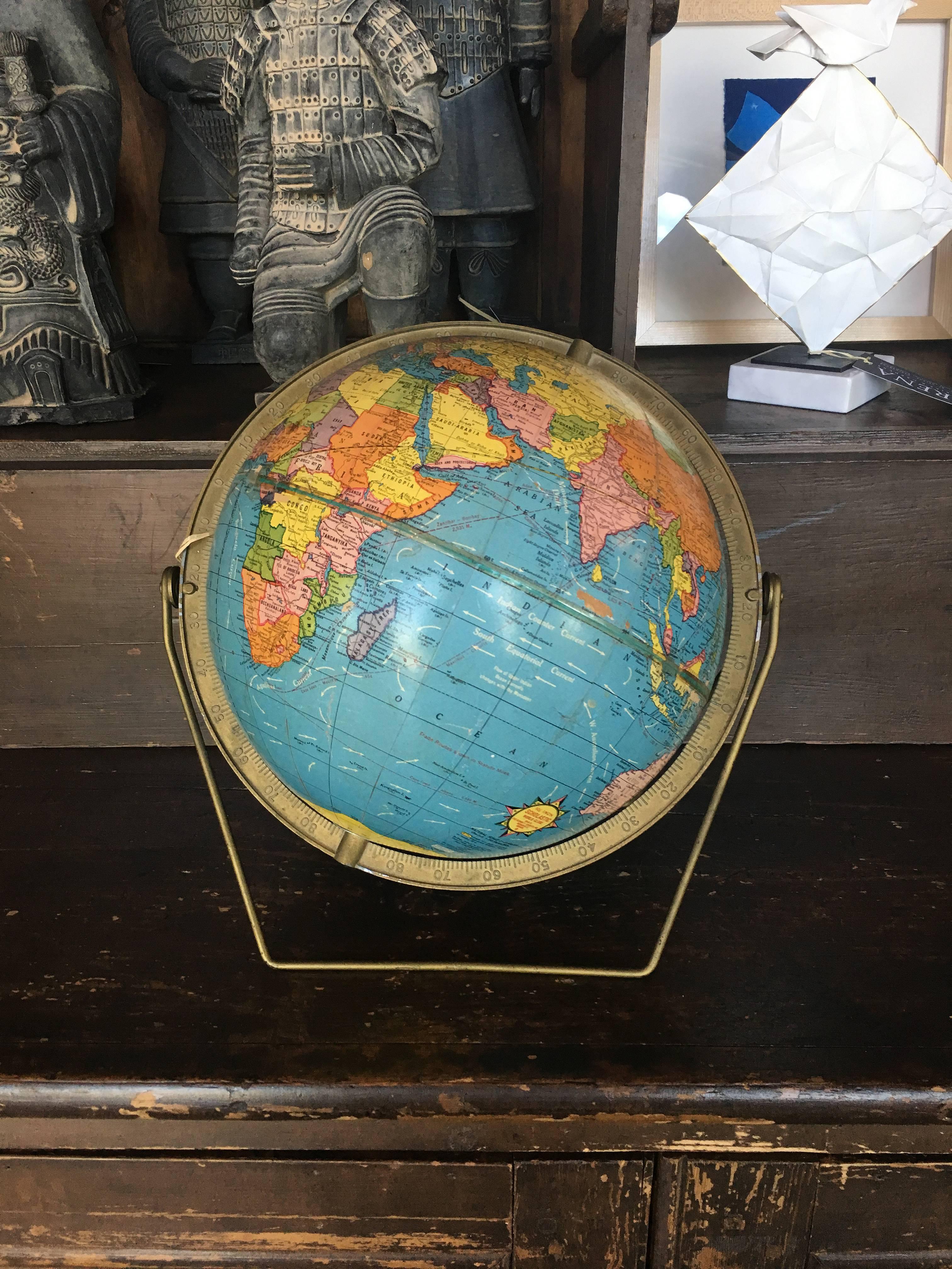 Vintage Scholastic world globe with a rotating stand. Measure: The globe diameter is 10 1/2 inches.