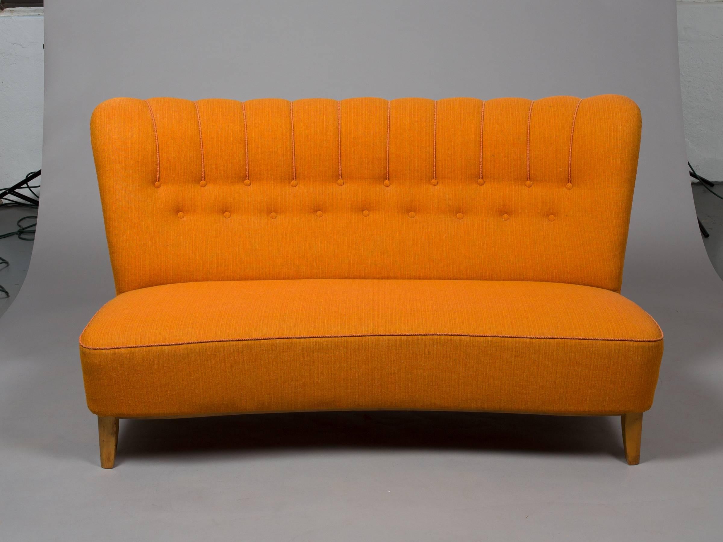 Stylish, Midcentury Danish armless settee with birch legs and button tufting. Upholstered in an orange textural fabric. Matching pair of chairs available. Seat depth: 20.5