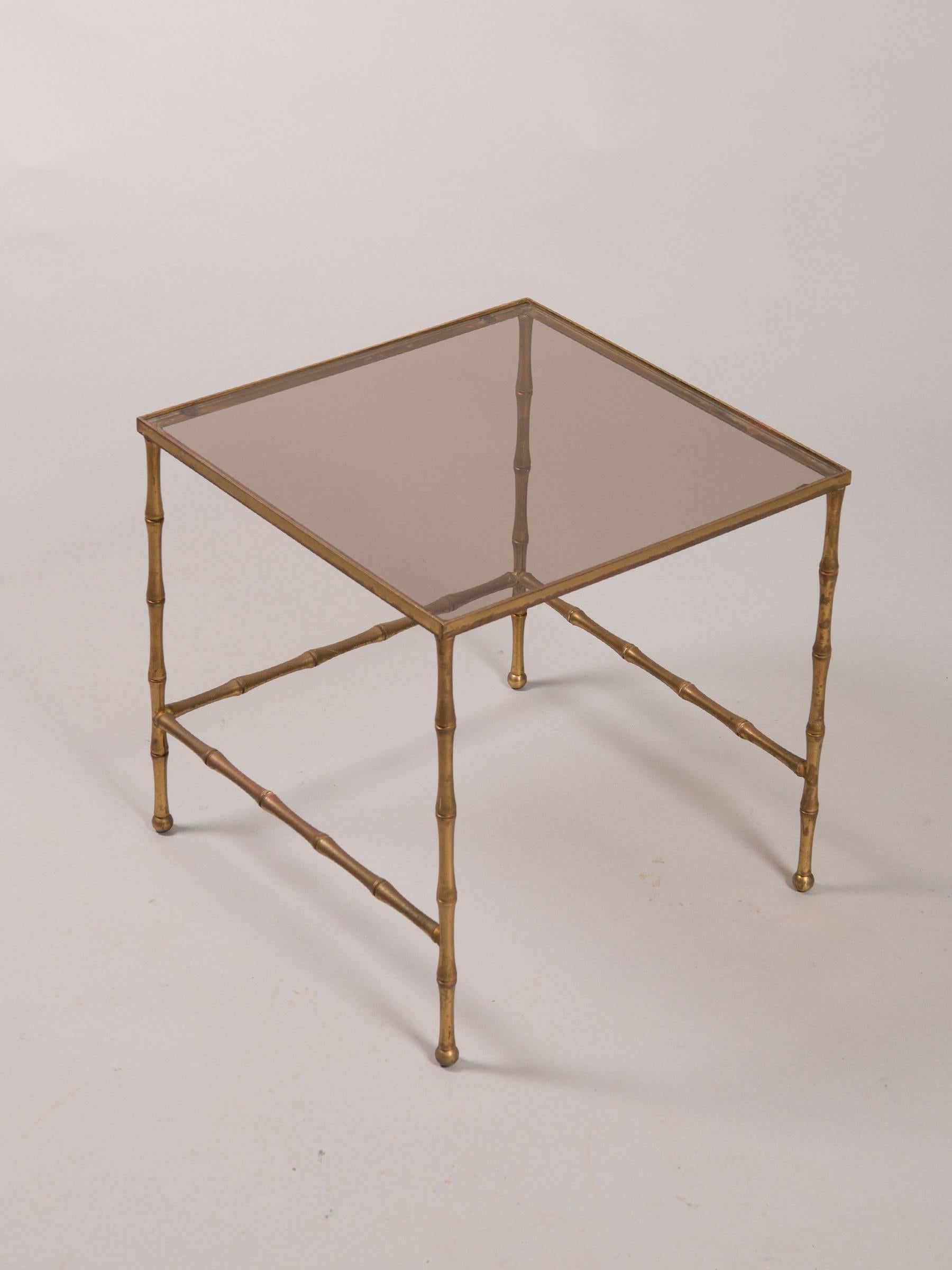 Set of three French faux bamboo gilt painted/distressed metal nesting tables with new smoked glass tops.
Large table measures: 19