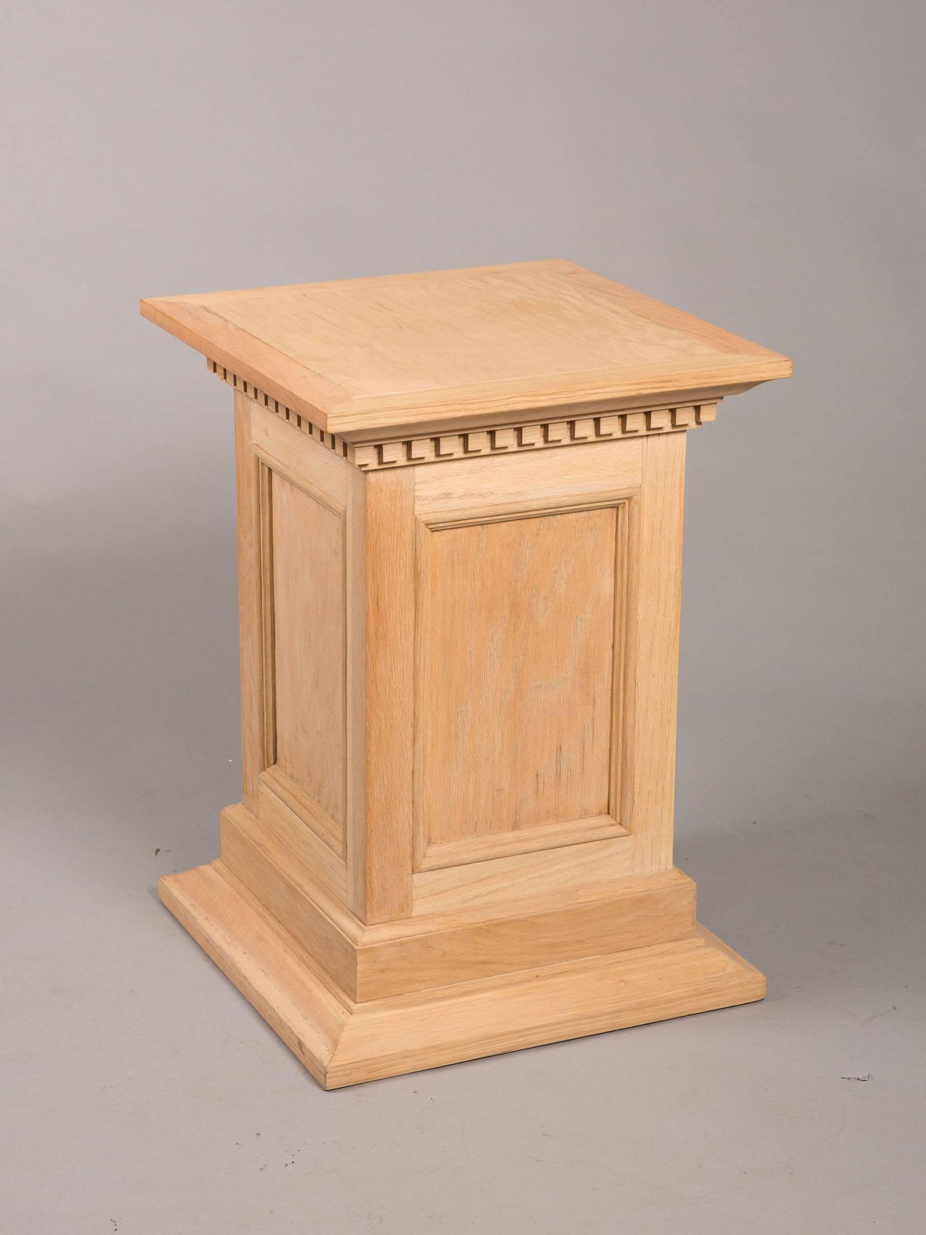 Pair of 1950s raw oak column pedestals with dentil molding and recessed panels.