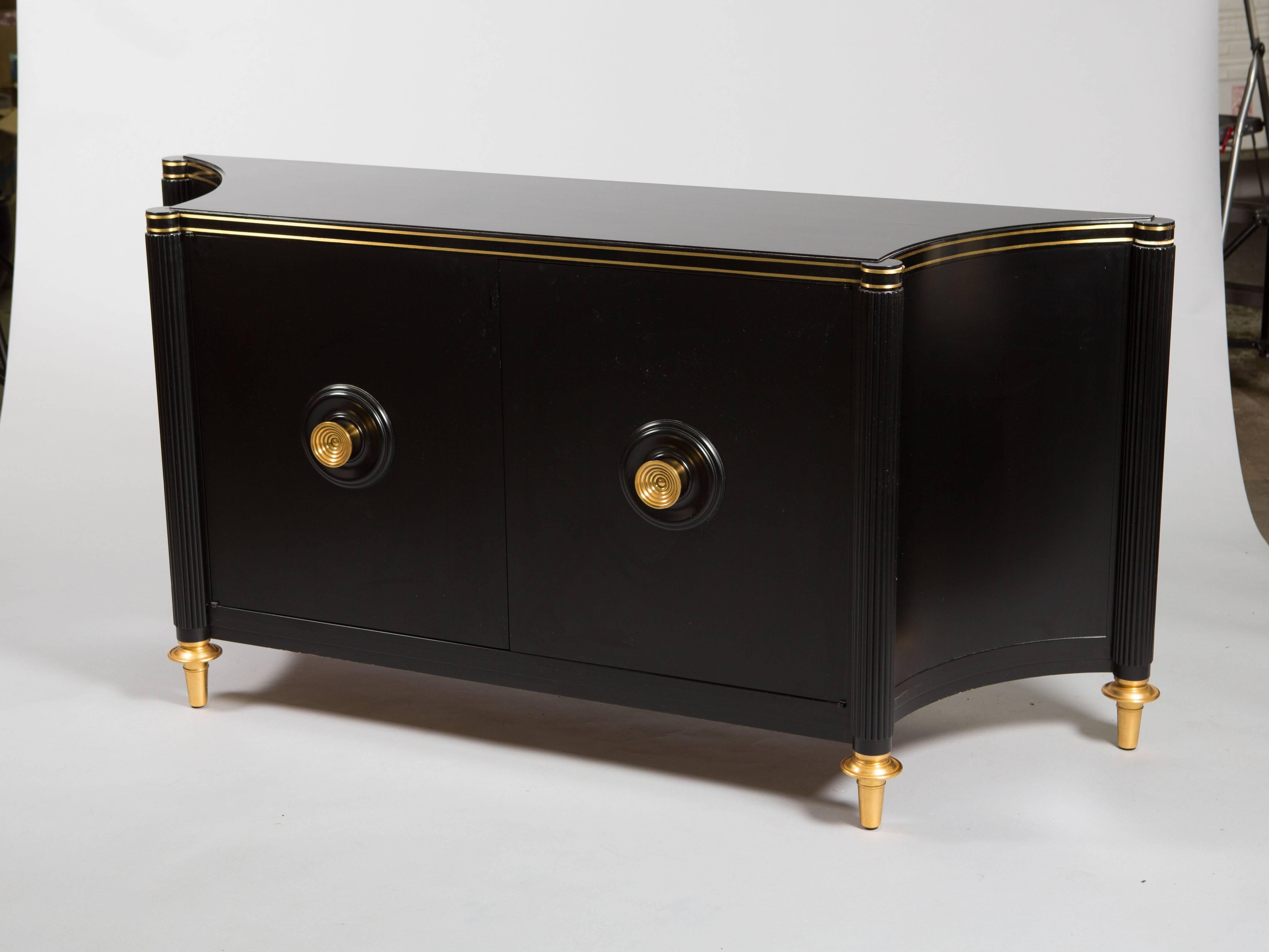 Tommi Parzinger black lacquered sideboard with brass knobs and edge details and brass tapered feet. Custom fabric panel made for each shelf.