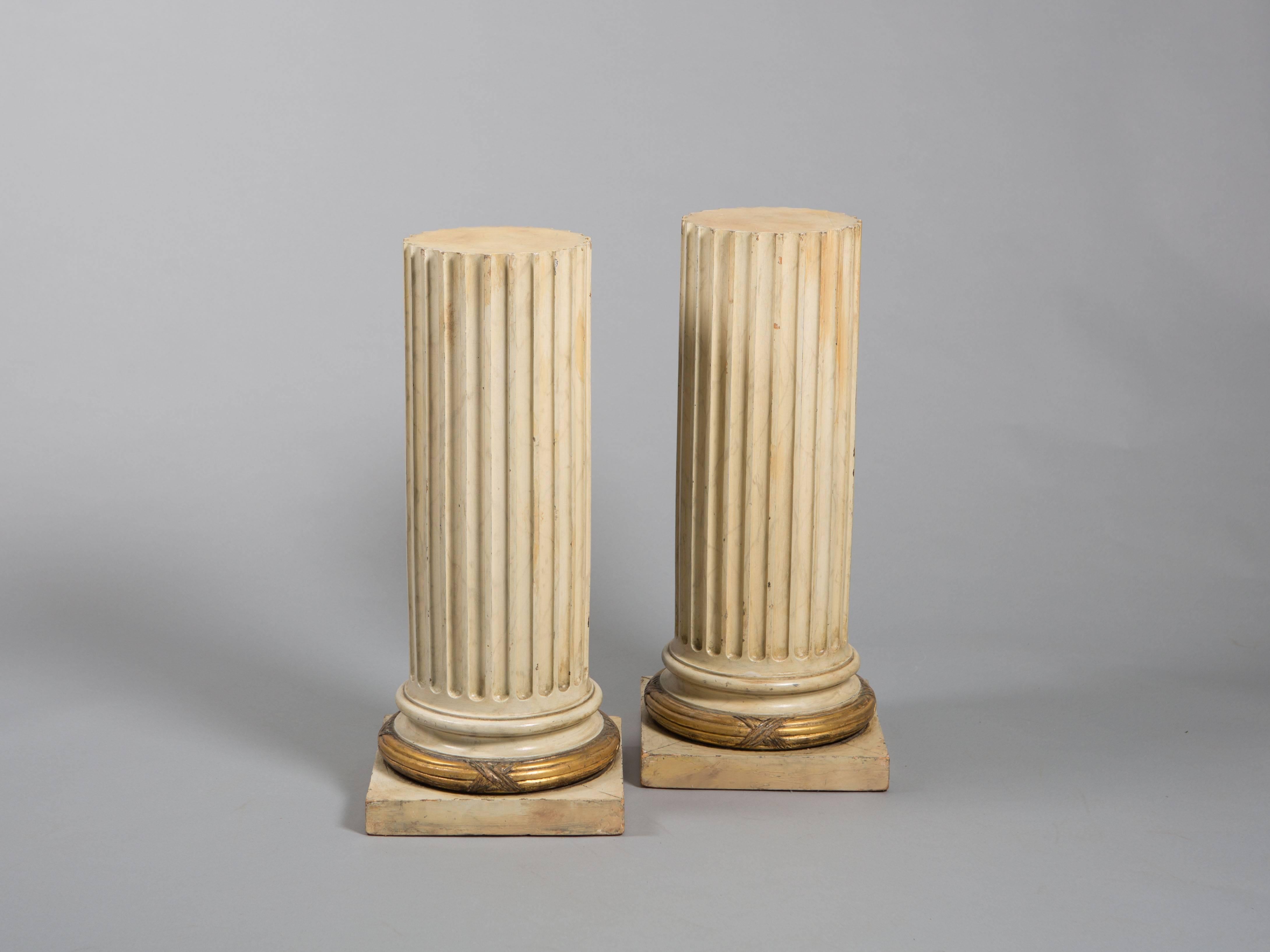 Paire de colonnes cannelées en bois avec bandeau doré sur la base. Les colonnes montrent magnifiquement leur âge. Petites fissures dans la base qui n'affectent pas leur intégrité structurelle.