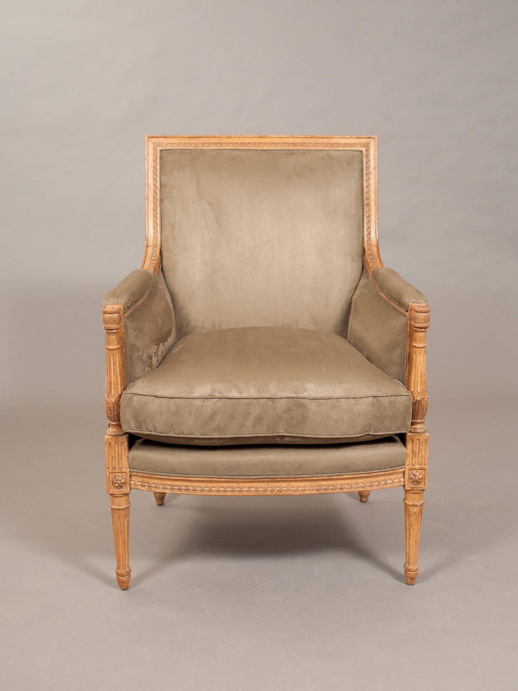 Élégante bergère en faux daim de style Directoire avec des pieds cannelés et effilés et des détails d'accoudoirs en colonne incurvée. Bois de couleur naturelle montrant un grand âge à travers avec de grands détails arrière exposés.
20.5