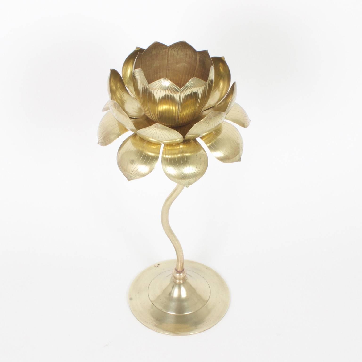 Exotic, Mid-Century lotus candlestick crafted with brass. The cup will hold a votive or wide candle surrounded by leaves with etched veins sitting on top of a realistic stem on a classic turned base. Newly polished. Probably by Feldman.

.
  