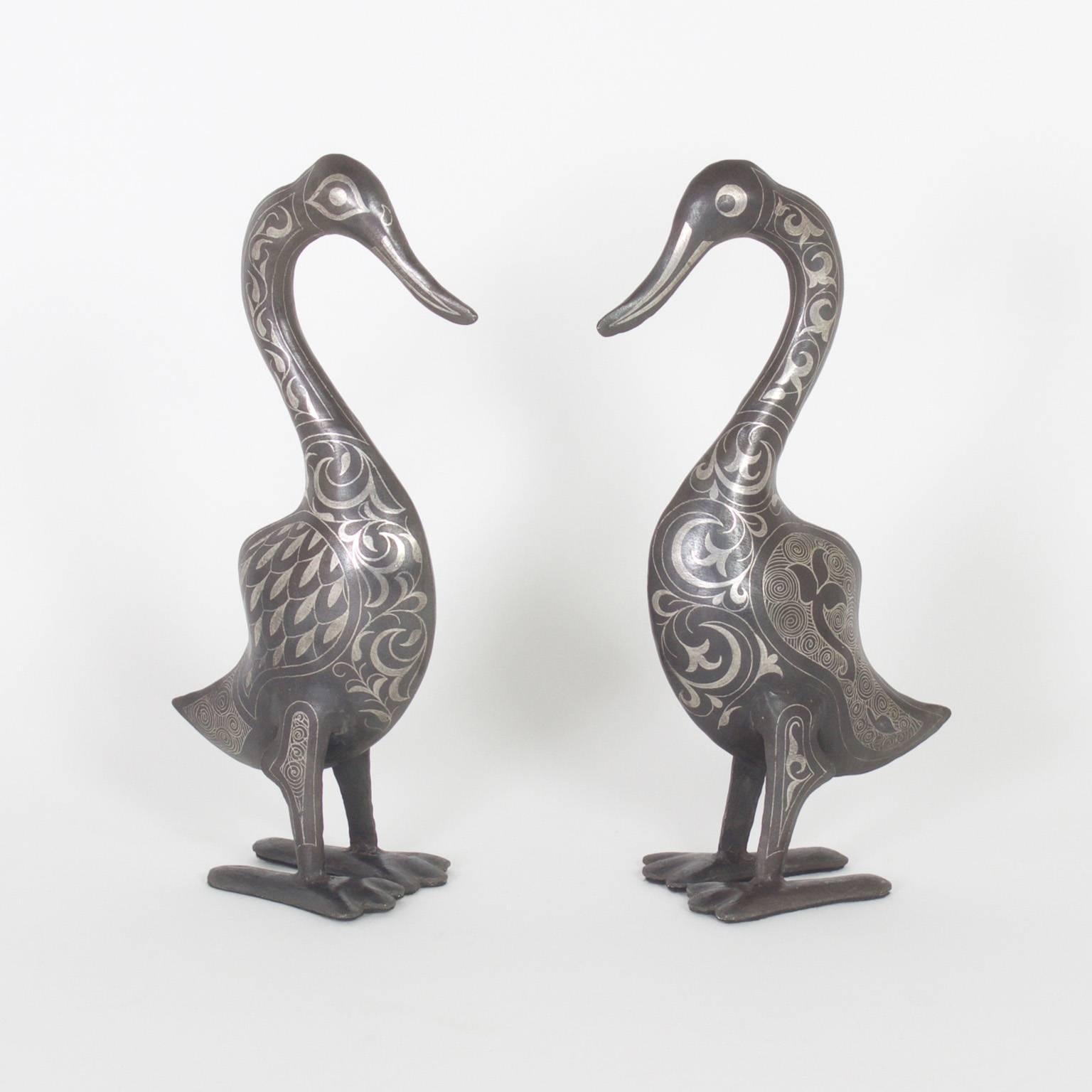 Amusing pair of Mid-Century Moroccan ducks crafted with an unconventional and ancient technique of applied silver on darker metal with a rustic patina. The combination of tones is quite alluring.