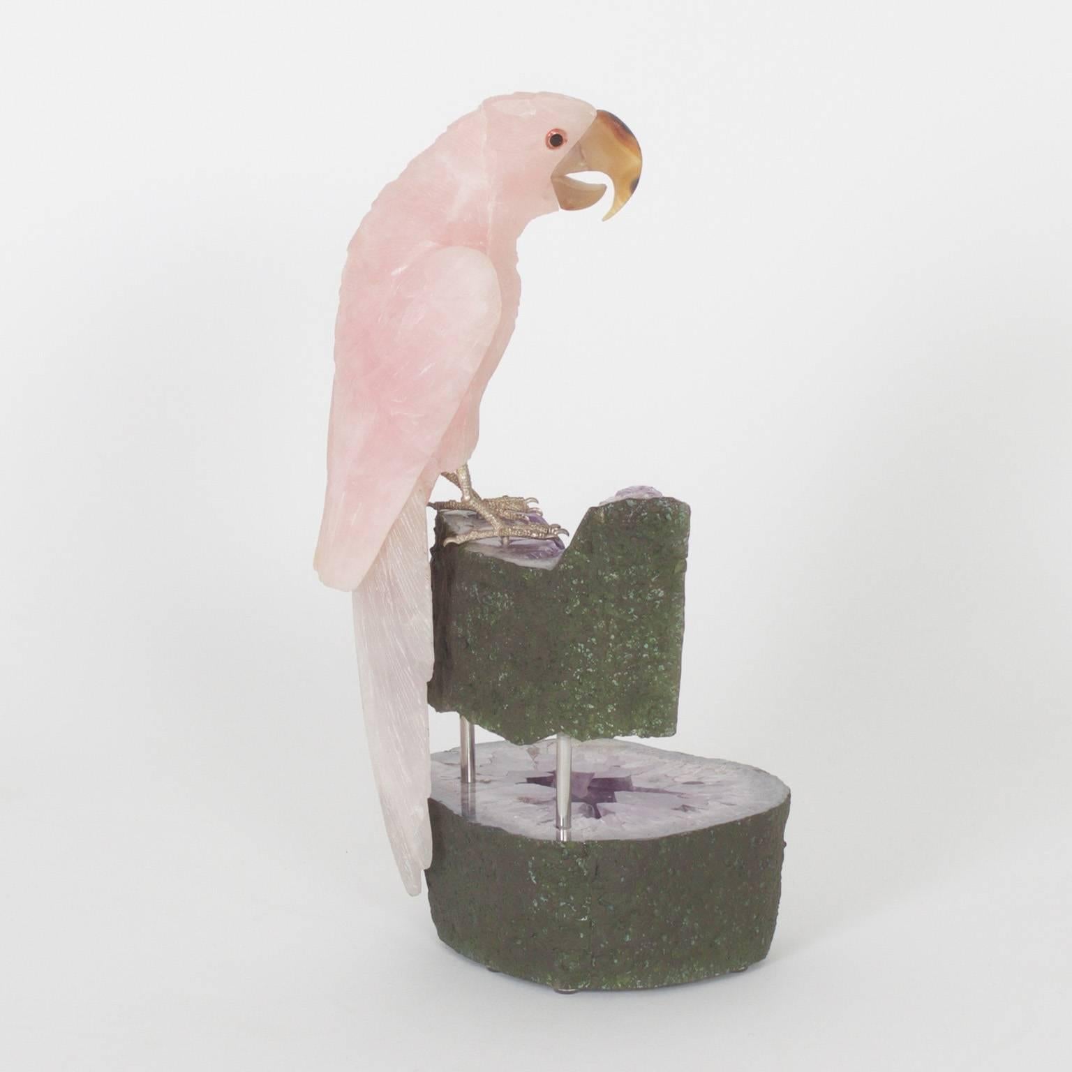 Parrot sculpture expertly carved from rose quartz with an amusing expression and an agate beak, presented on a two-piece geode stand.

.