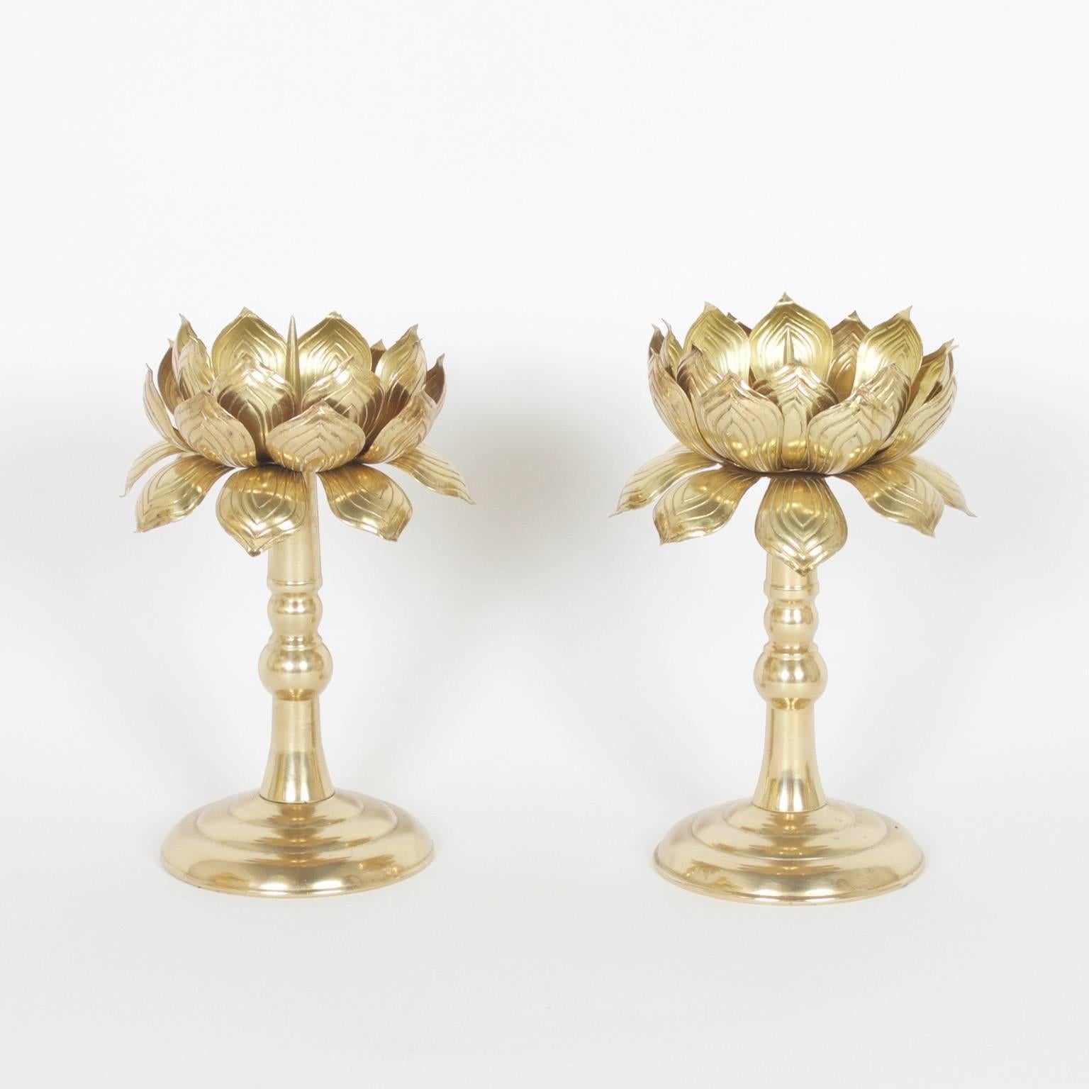 Create an exotic mood with this group of three Midcentury, brass lotus candleholders that include a pair of candlesticks with prickets elevated by a classical turned stem and base. A large three-tiered lotus flower with space for a wide candle.