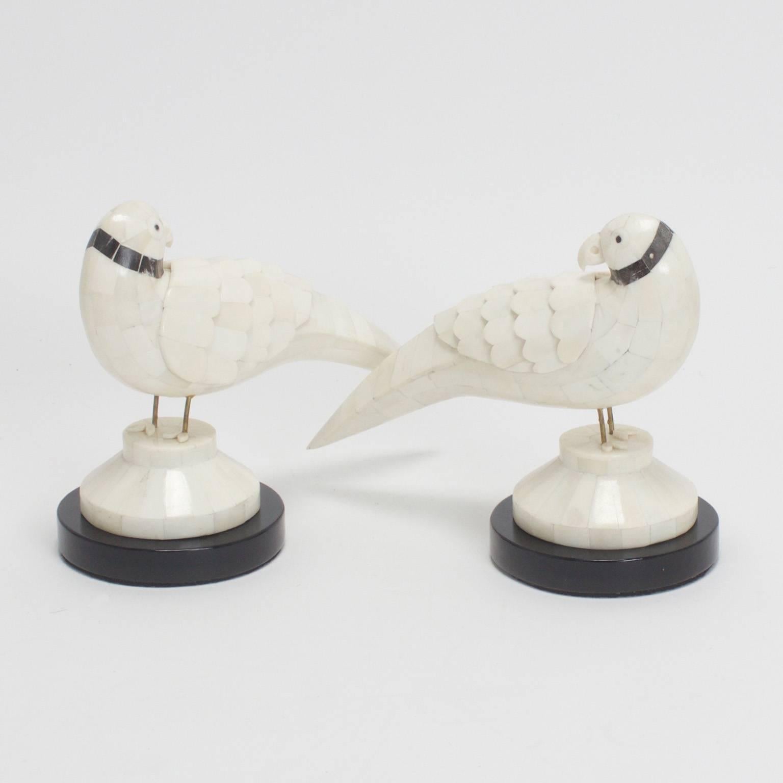 Mid-Century pair of stylized parrots crafted from bone in India and set in a unique kind of mosaic. Featuring an amused expression and dyed bone neck rings. Presented on custom ebonized plinth bases.


 