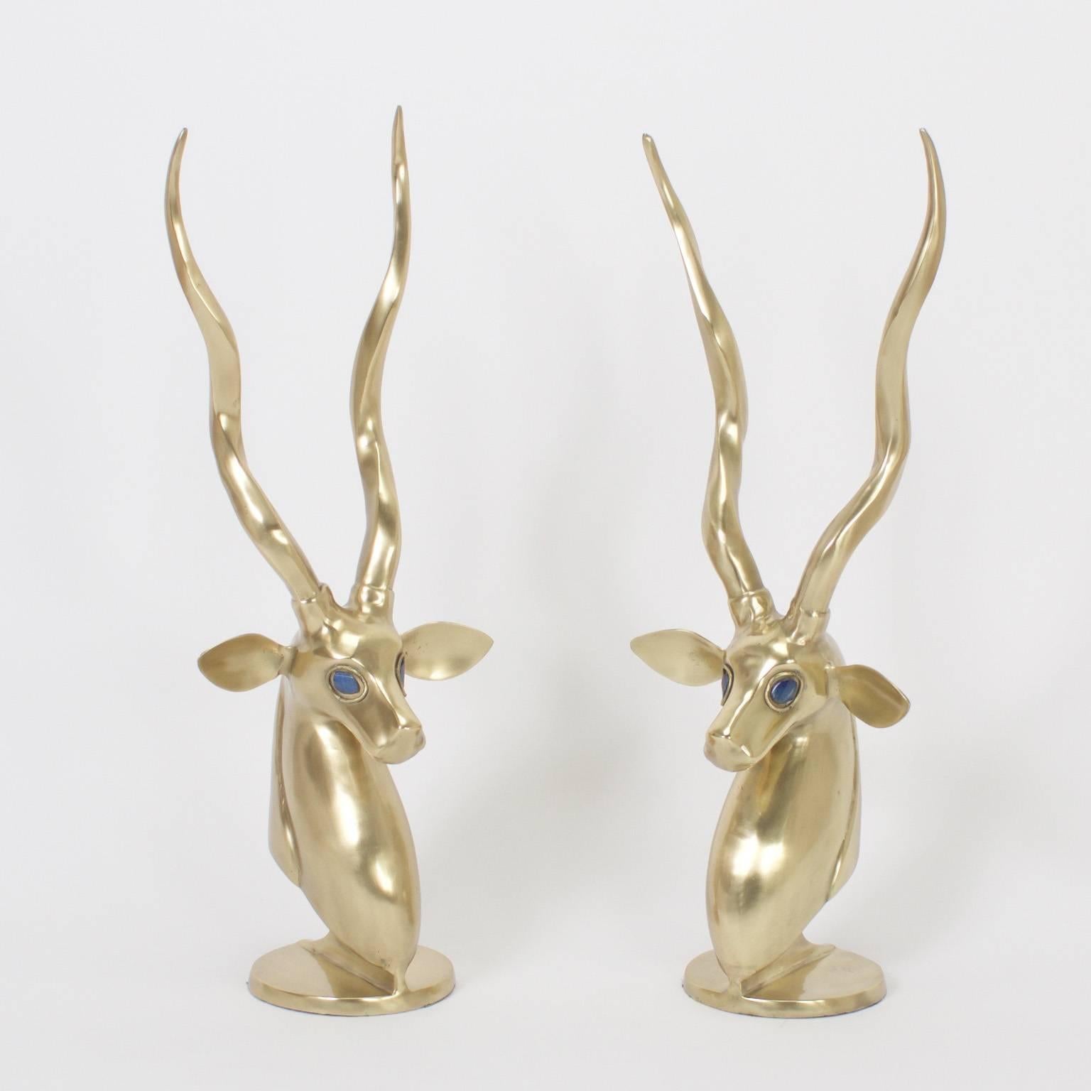 Striking pair of Mid-Century stylized brass gazelles with a strong, simplified approach. Set off with semi-precious blue stone eyes and presented on round sculptural bases. Executed in the style of Anthony Redmile.

.