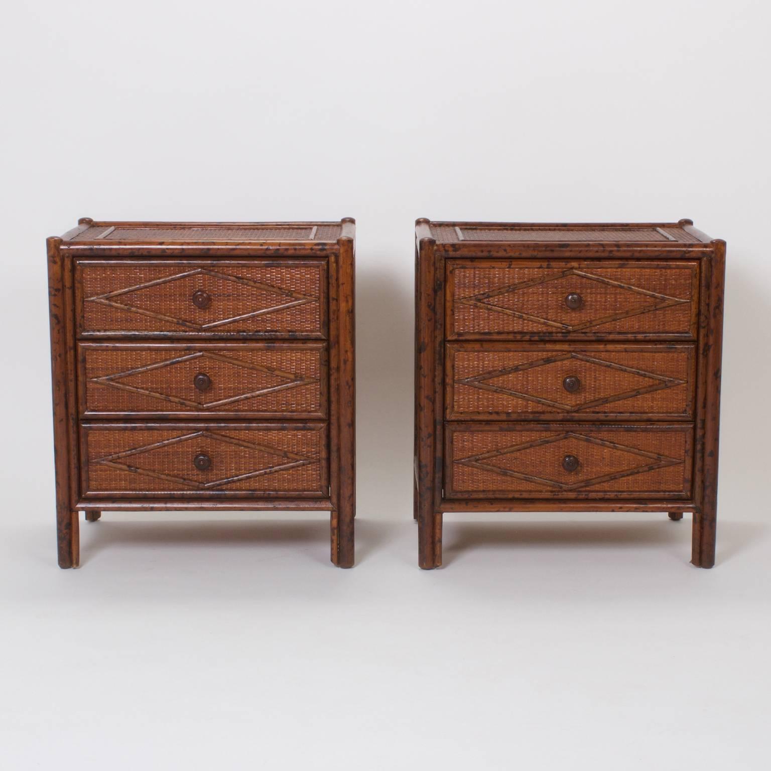 Dapper pair of three-drawer chest or nightstands, crafted in the Mid-Century with an organic mixture of materials, that feature geometric shapes of faux bamboo set on a grasscloth background, timeless yet modern.
 