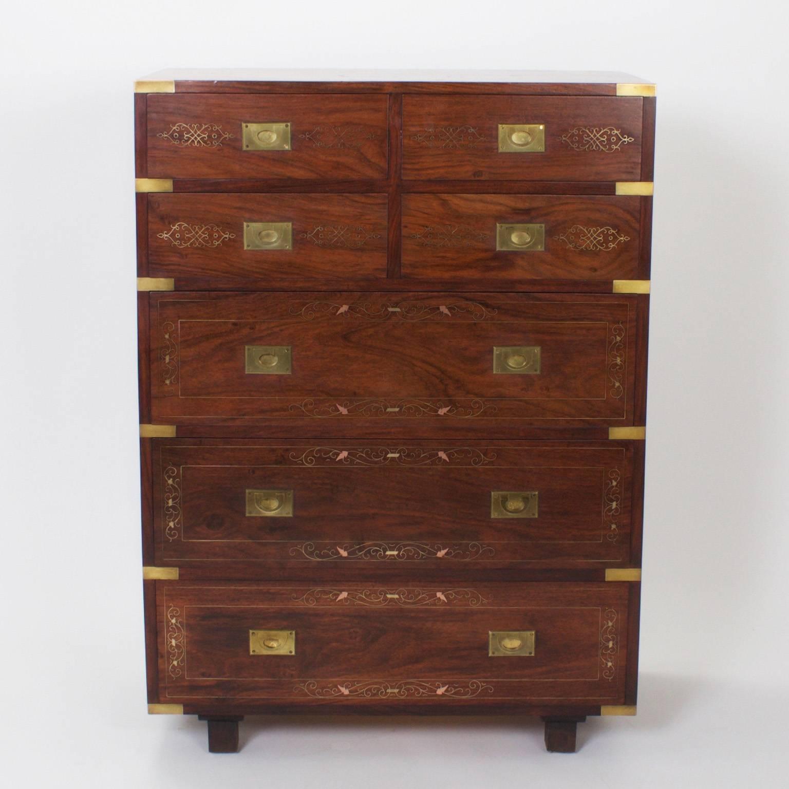 Handsome antique Anglo Indian campaign chest of drawers that stands aside from the typical. Crafted with beautifully grained mahogany and decorated with elegant brass and copper inlays. The brass hardware is campaign style, the sides are paneled,