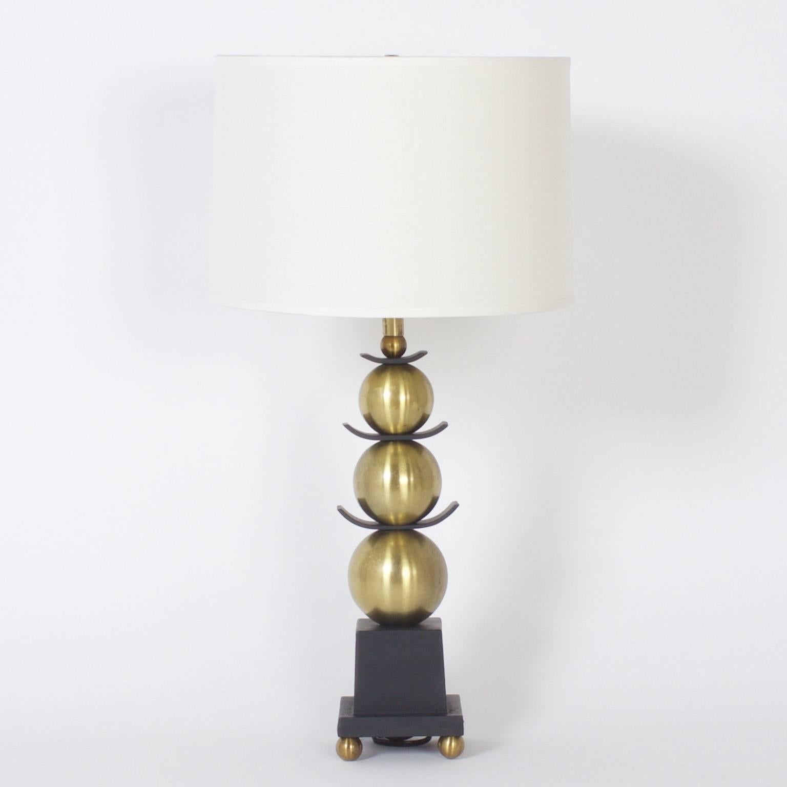 Swank pair of midcentury, Asian Modern stacked ball table lamps with a strong James Mont vibe. Crafted of spun brass and ebonized metal. Newly wired.