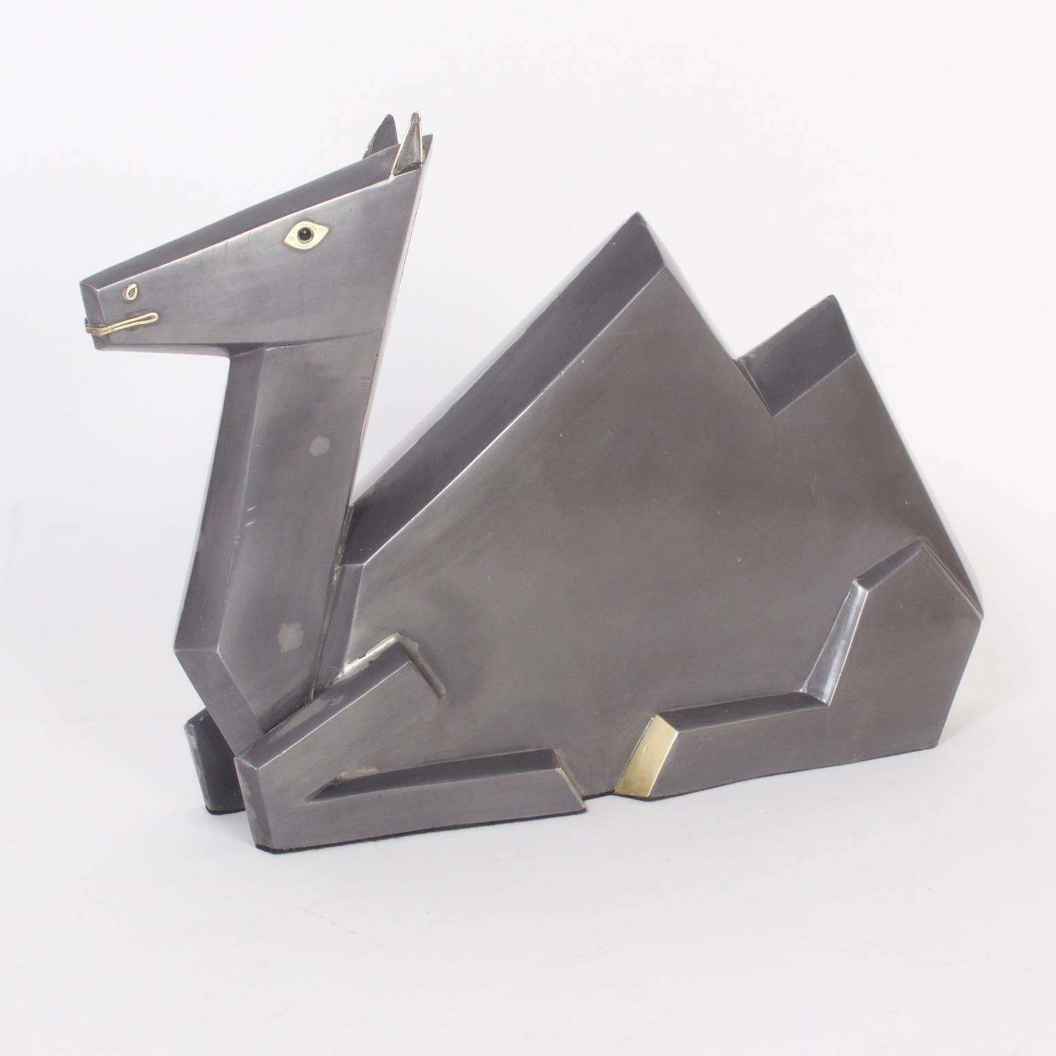 Cubist style camel sculpture expertly crafted in the Mid-Century with zinc and brass. The camel, who is in repose, has a soothing, satisfied expression.
  