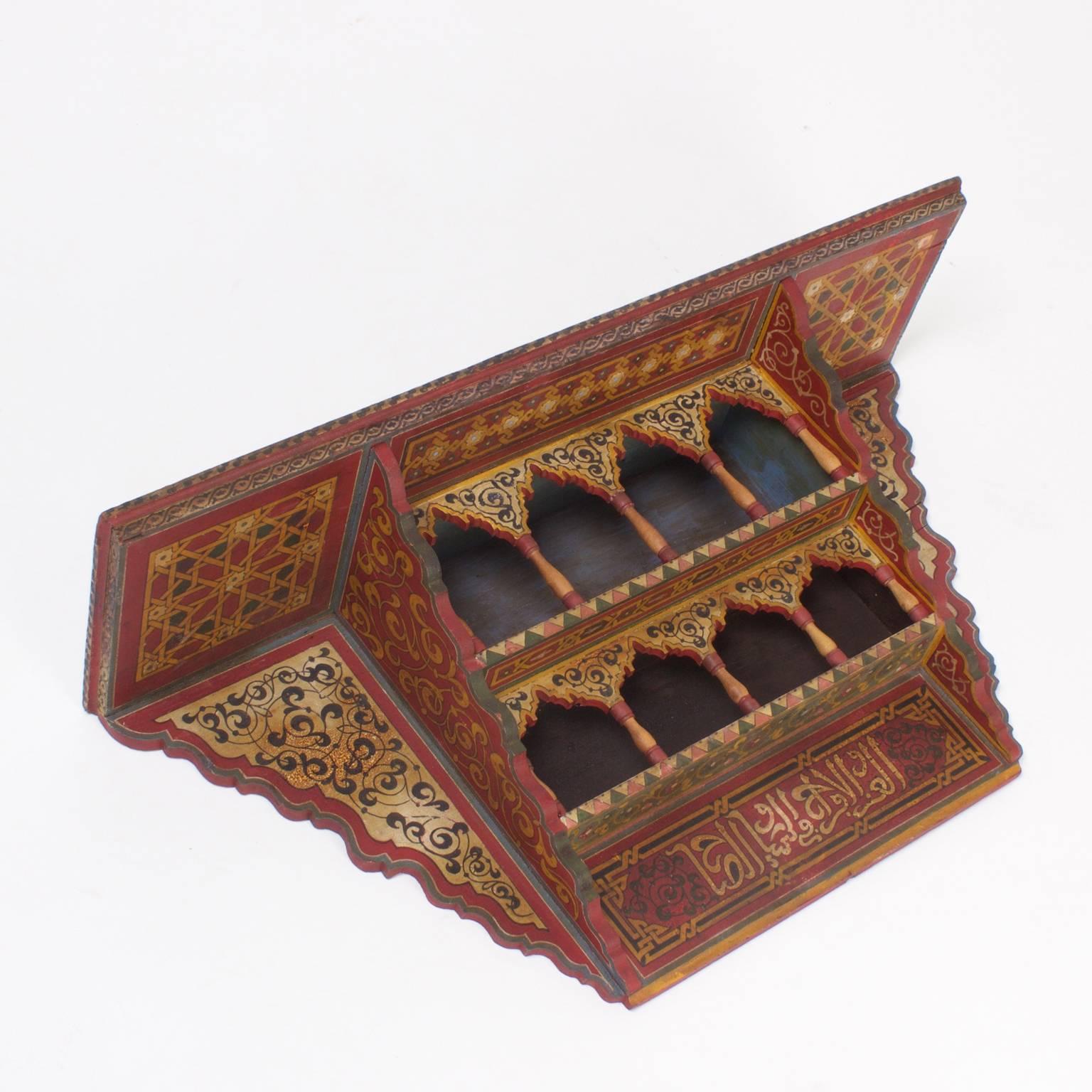 Delightful, Moroccan wall shelf or bracket painted in distinctive floral and geometric patterns with muted reds, yellows, and greens. All of this over arches and columns is representative of Moorish architecture.