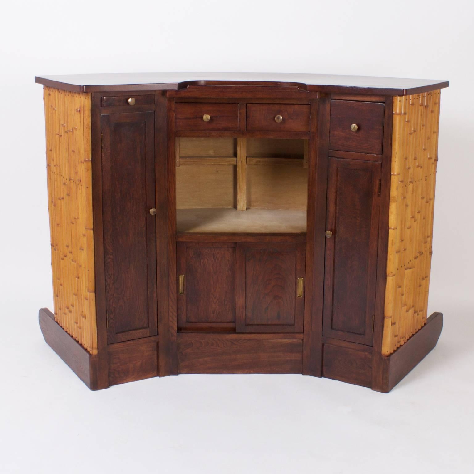 Sophisticated 1940s bamboo or rattan tiki bar expertly crafted with an oak top and base with a brass footrest. The service area in the back features a zinc lined ice drawer, slide out cutting board, and over all yacht like aesthetics.