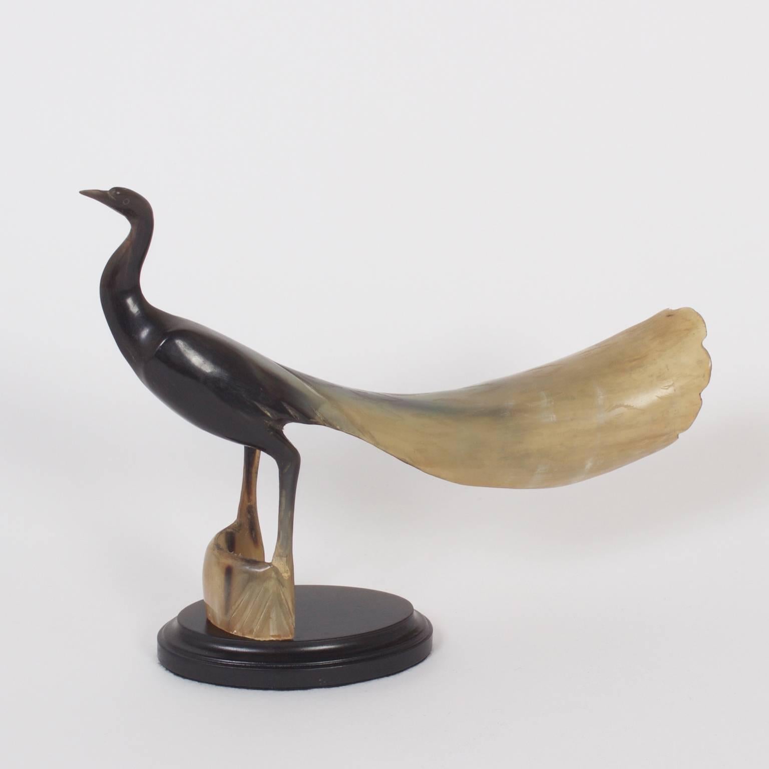 Pair of carved and polished steer horn birds with graceful lines, organic variegated colors, and an elegant presence presented on wood stands.
 