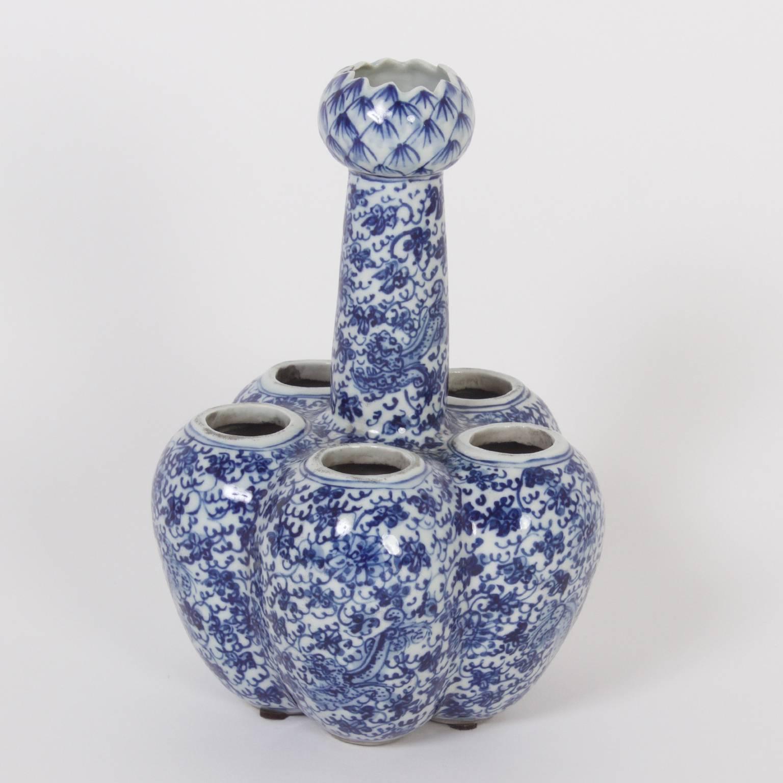 Rare pair of Chinese Export style blue and white porcelain tulipieres, each with five openings in the base for tulips to bloom from bulbs with a watering spout in the center. Decorated in a lovely, intricate floral design throughout.