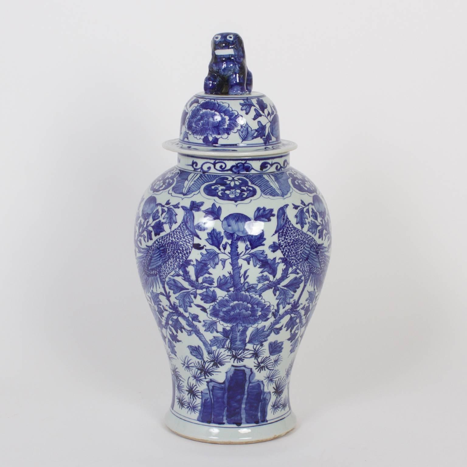 Inspired pair of Chinese export style blue and white porcelain lidded jars decorated with two phoenix birds facing centre over an elaborate floral field.

