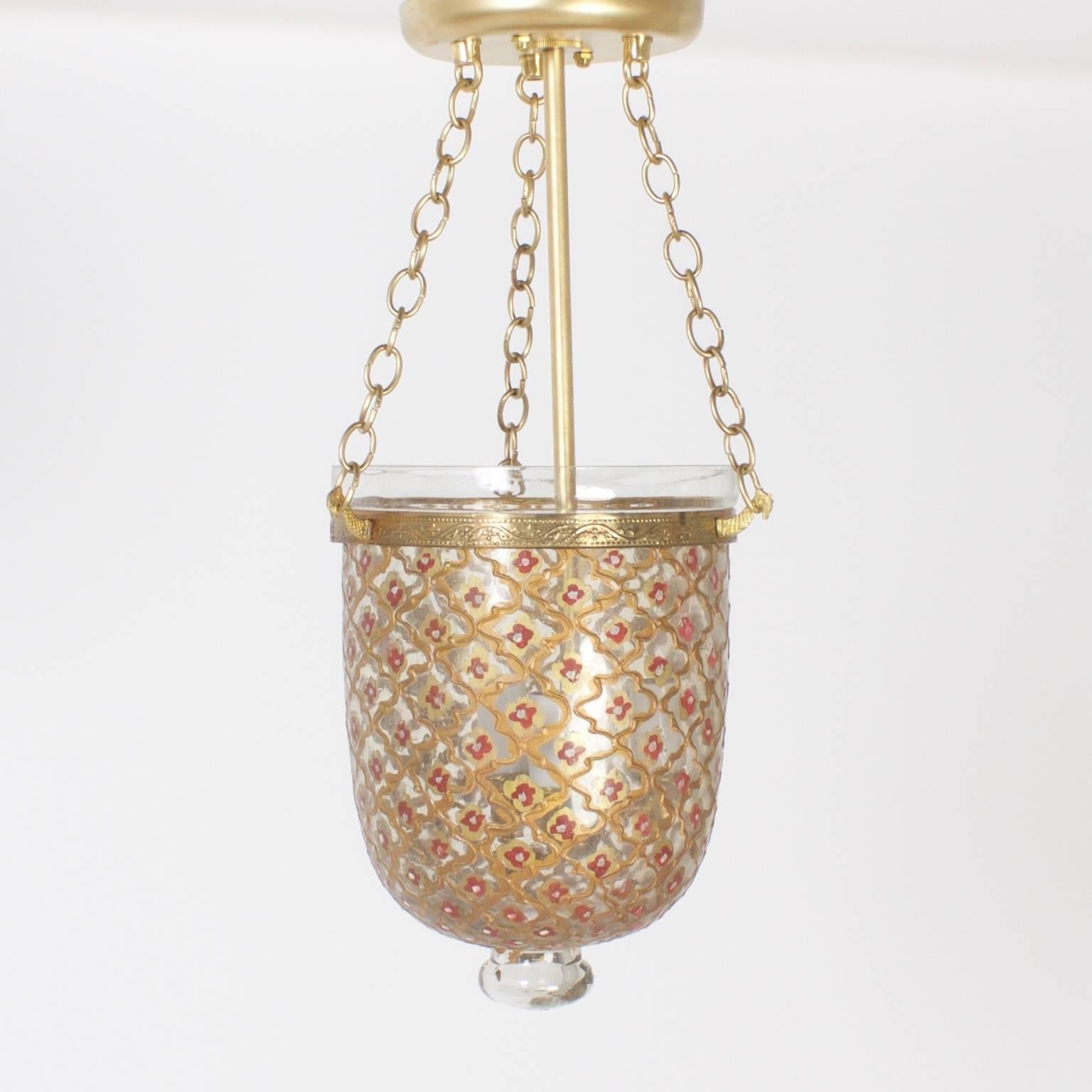 Intriguing pair of handblown bell jar lanterns enameled in a Mediterranean style of repeating cartouche and flower patterns that cascades romantic light into a room.

