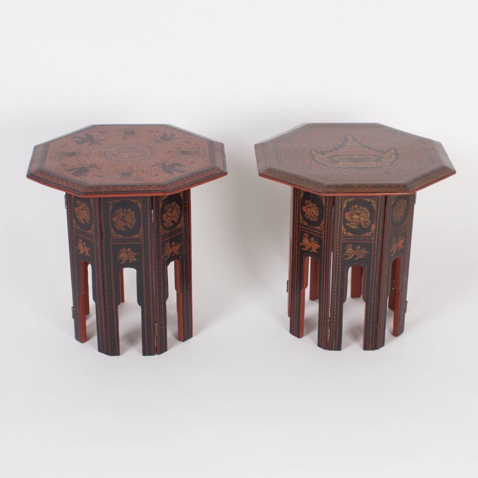 Rare pair of Burmese end or occasional tables with octagon tops both with hand painted intricate floral and geometric fields and a cast of symbolic, spiritual characters. The  bases have an architectural element and are decorated with the same