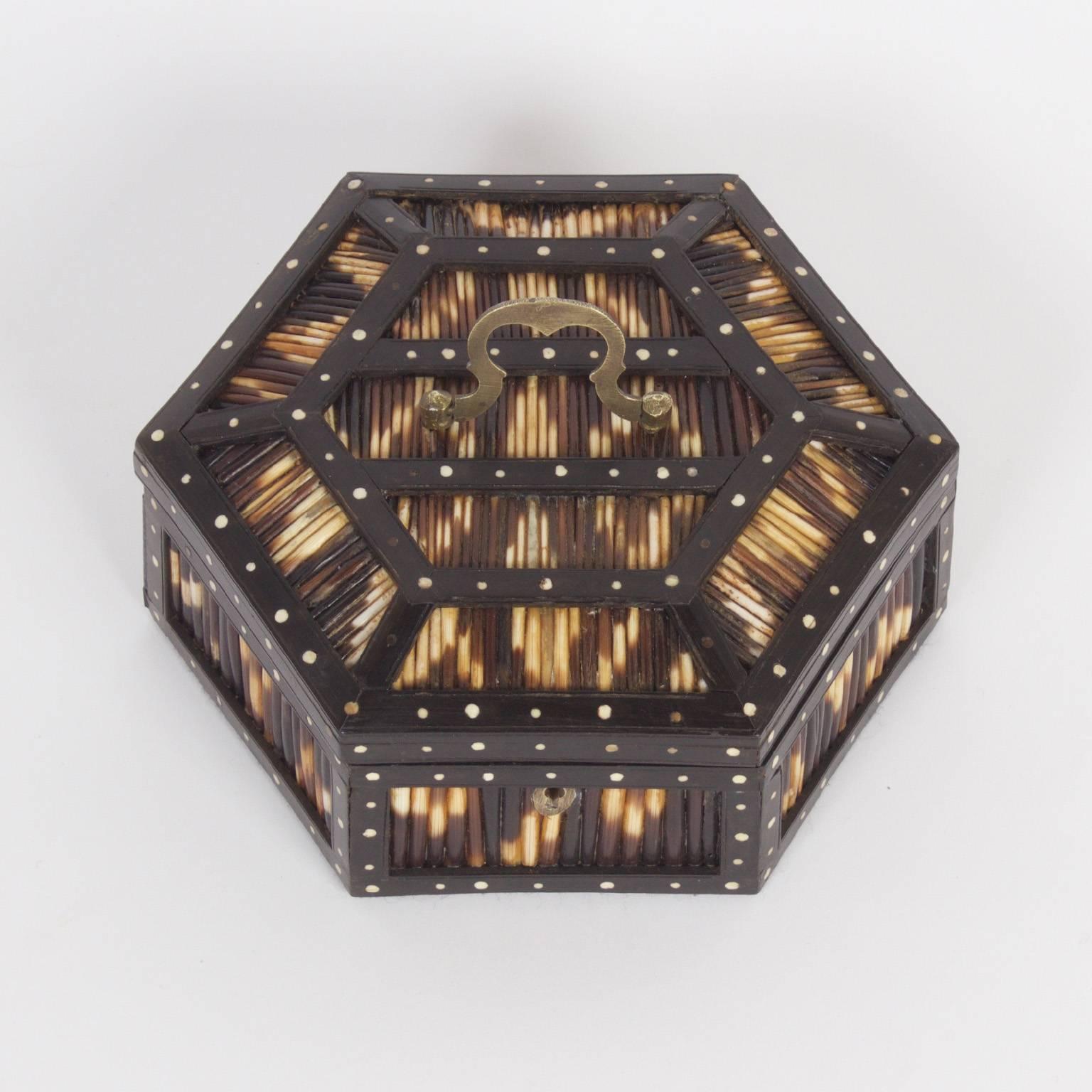 Anglo-Indian porcupine quill box crafted with a hard wood hexagon shaped frame decorated with inlaid bone dots. Inside the lid is a carved bone elephant a top a Ceylonese plaque.
        