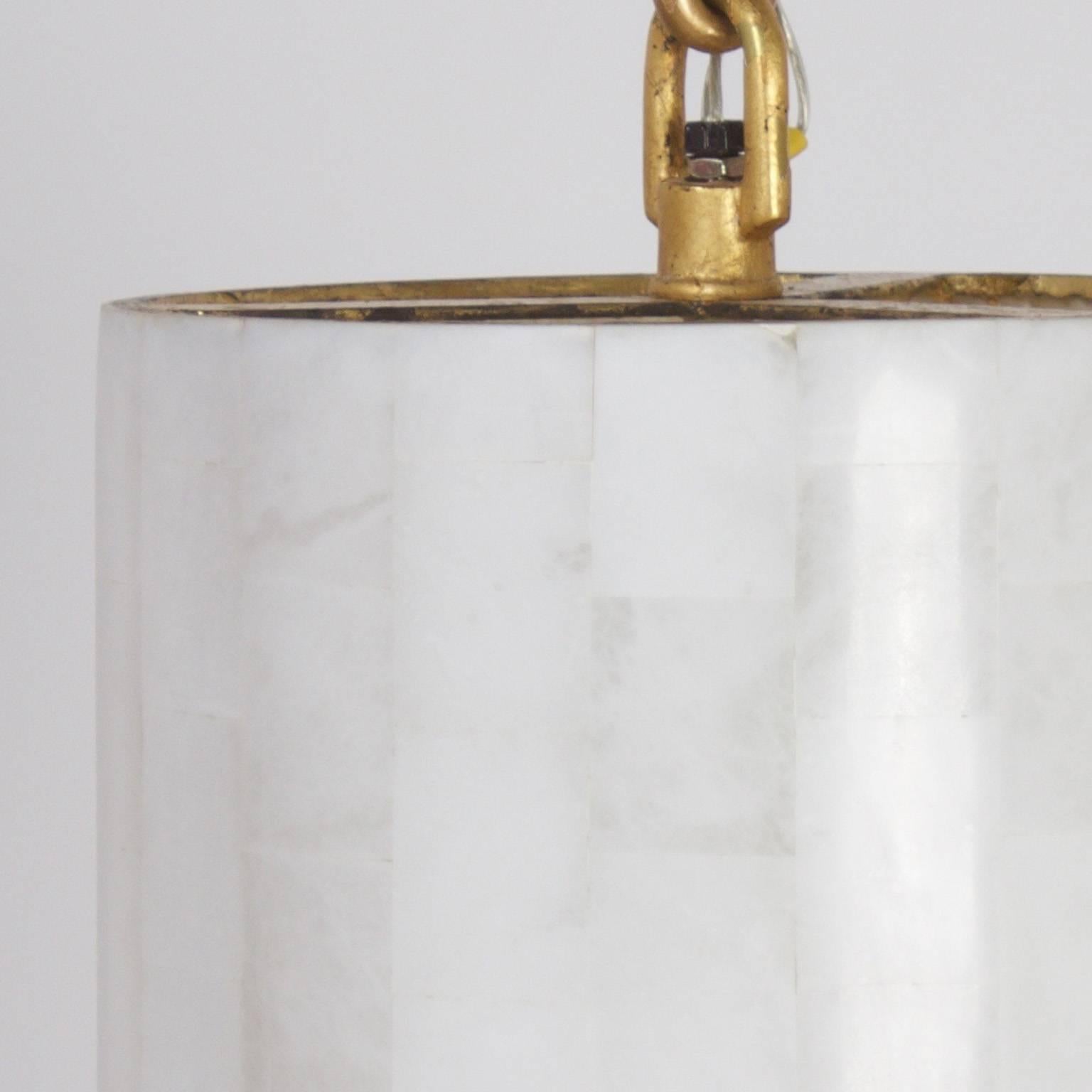 Elegante y moderno colgante en forma de lápiz teselado con un sencillo ambiente de estilo de mediados de siglo. Los herrajes bien trabajados son de pintura dorada sobre hierro.

