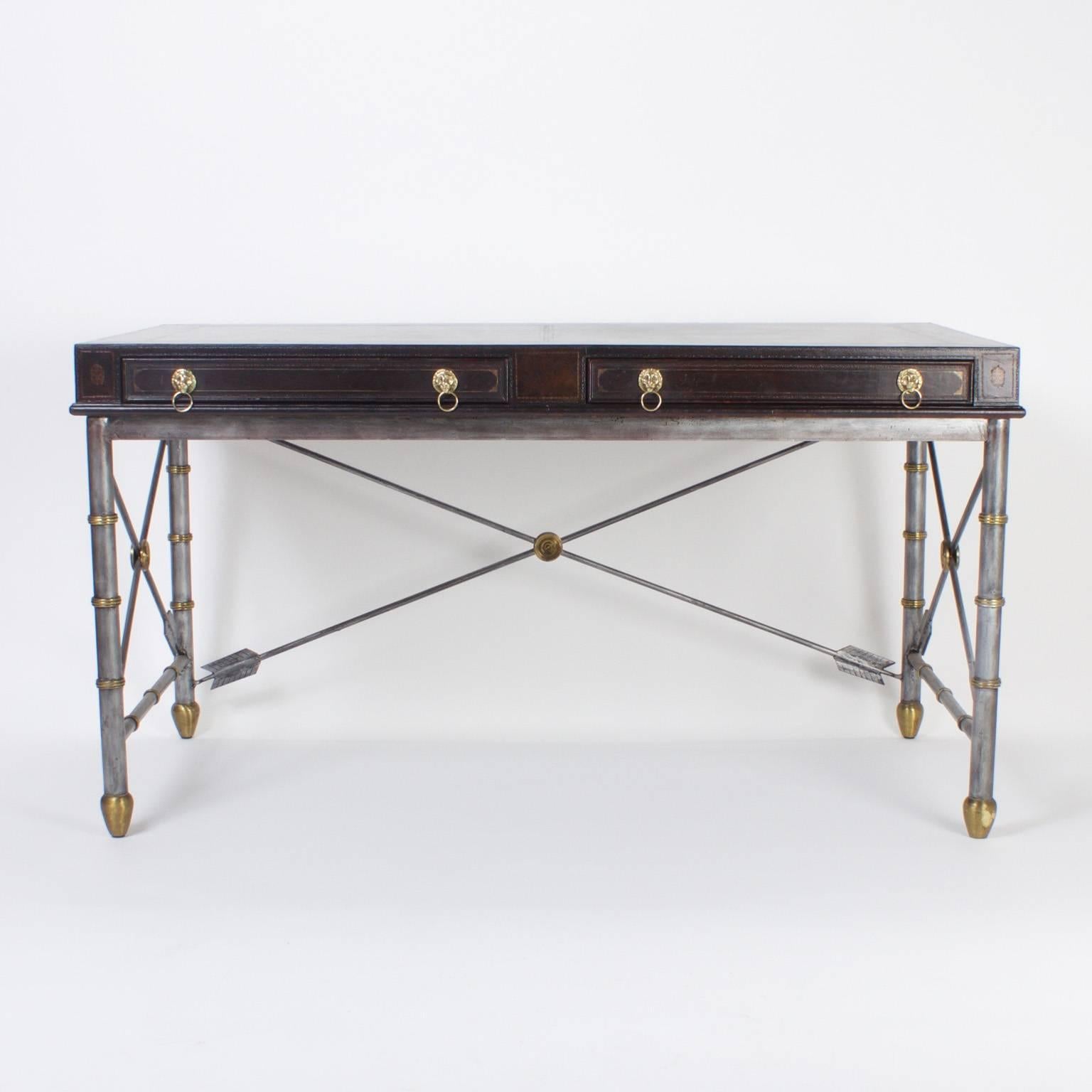 Here is a handsome Maitland Smith desk or writing table with an unusual combination of materials and influences. The top is tooled brown leather and has two drawers lined with book lining paper and lion head pulls. The base is a neoclassic design,