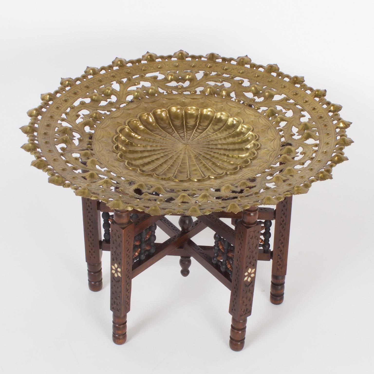 Moroccan tray, coffee or cocktail table with a hand hammered removable brass tray, featuring floral and geometric designs crafted with open filigree and old world charm. The base has carved, turned legs, inlaid bone and stick and ball supports.