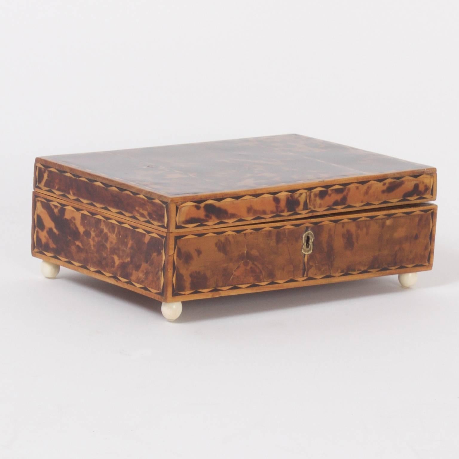 Charming antique Anglo Indian box and key crafted with hardwood and decorated with tortoiseshell and exotic wood veneers.
