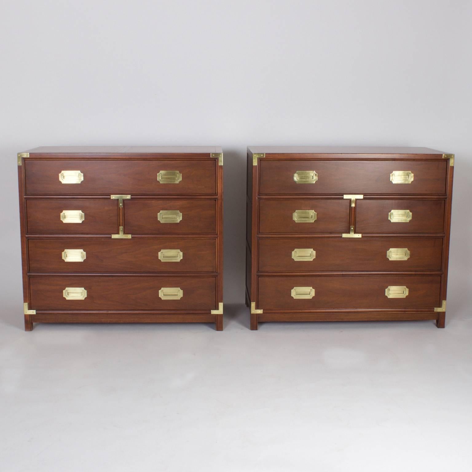 Handsome pair of vintage mahogany campaign style chests of drawers or large nightstands with classic simple form, inset brass hardware and well chosen wood grains. Signed Baker on a silver label.
 