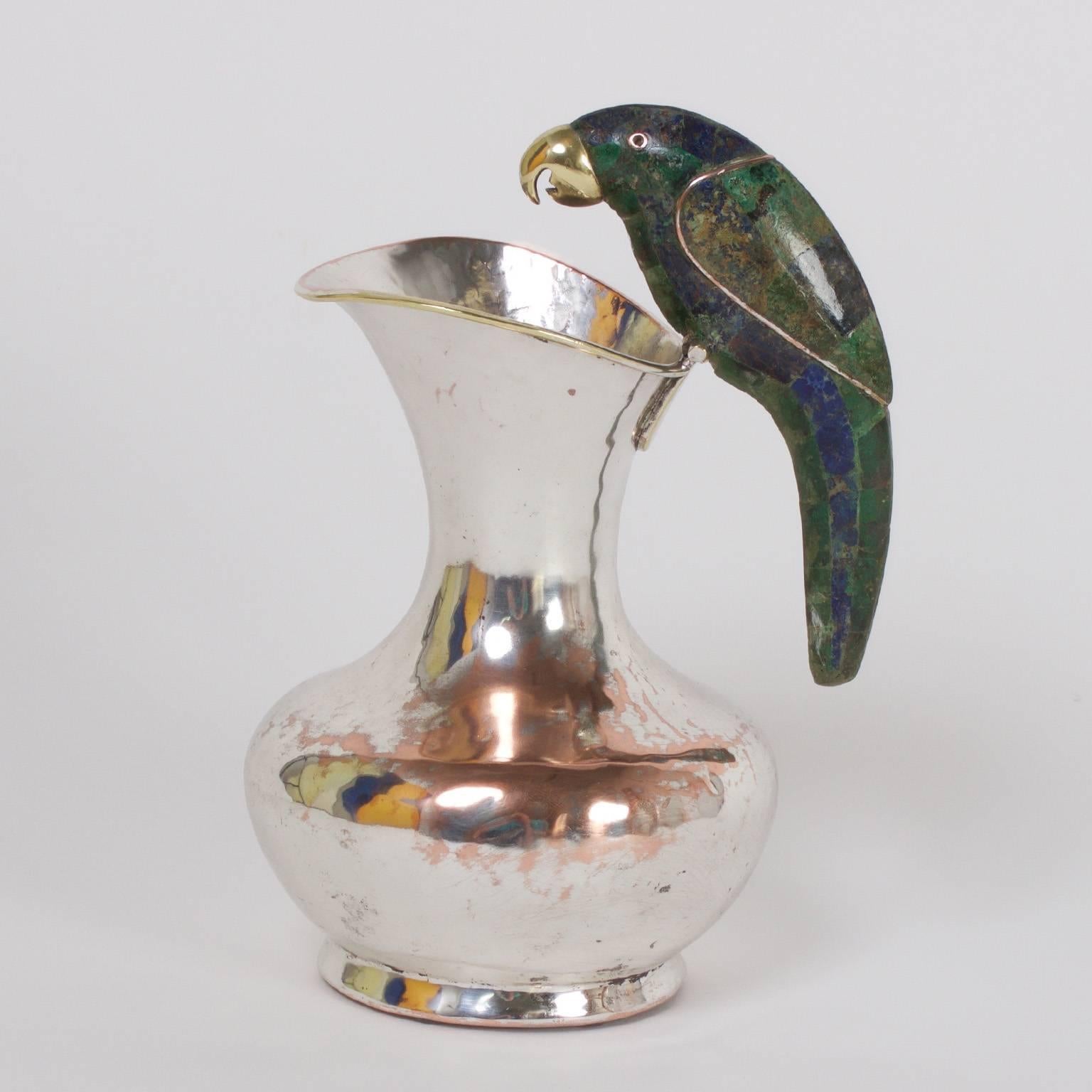Amusing Mid-Century silver plate over hand-hammered copper water pitcher with a green and blue lapis lazuli parrot handle. Signed Lily Castillo on the bottom.
 