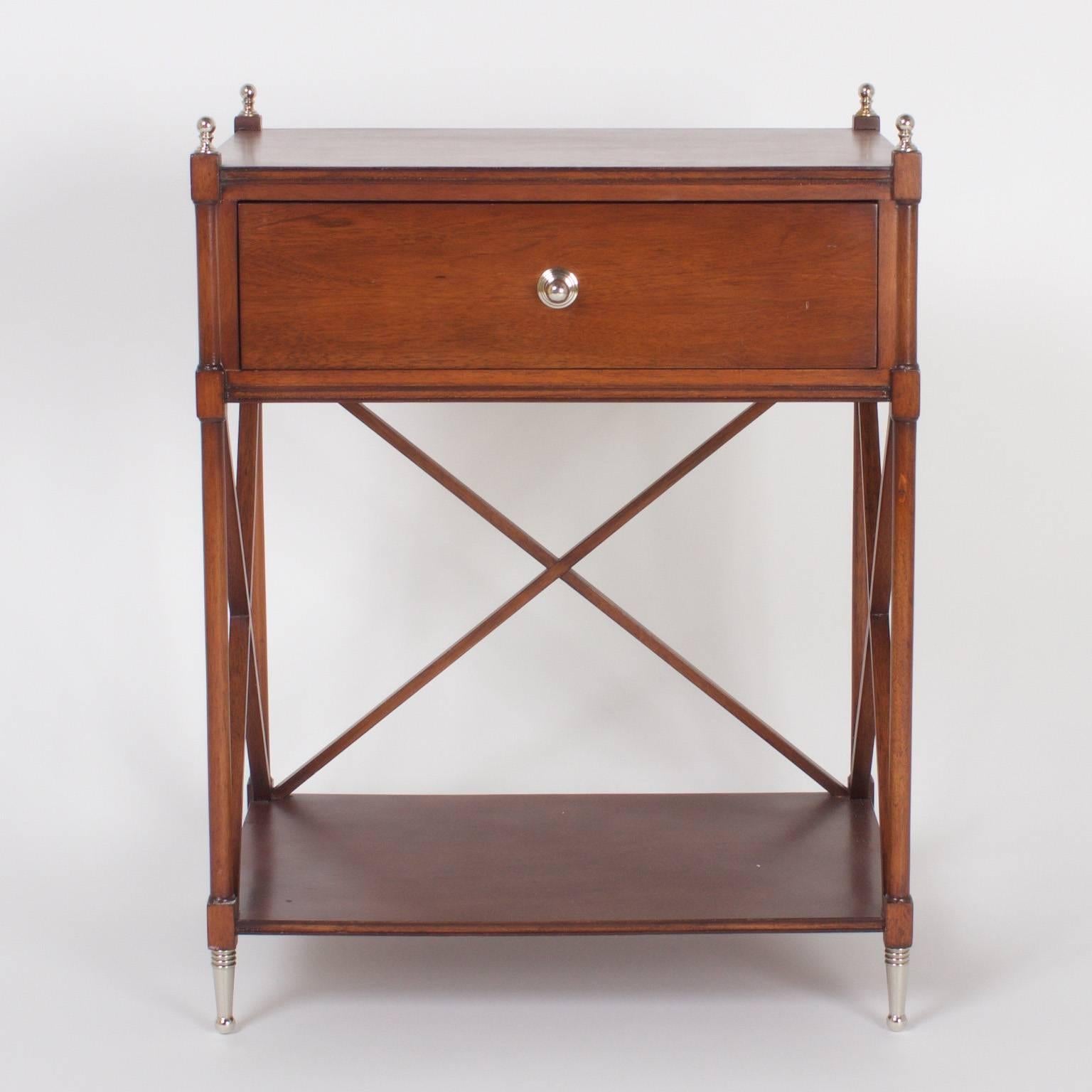 Elegant pair of mahogany nightstands or tables with strong lines and a mellow finish, trimmed with silver metal pulls, finials, and feet. The perfect bridge between modern and classical.