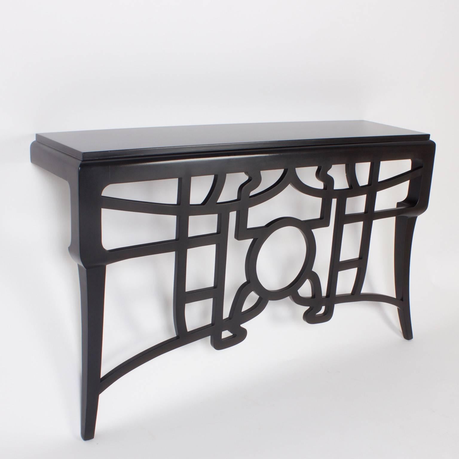 Chic, black lacquered wall mounted console table with a hip deconstructed Chinese Chippendale motif between splayed Asian legs.
 
