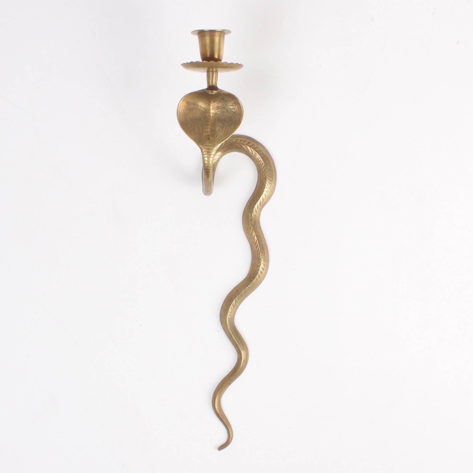 Unique and exotic pair of vintage, candle powered cobra sconces crafted in brass and inscribed with detailed snake skin.
  