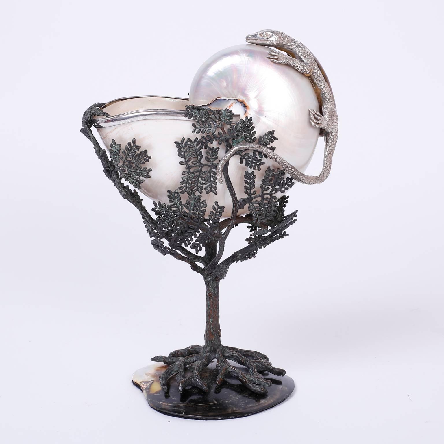 Here is a Mid-Century object of art that defines fantasy with an unlikely combination of materials and subjects as if in a dream. Silvered metal lizard sits atop a nautilus shell inside a metal tree with a bronze patina, mounted on a polished shell.