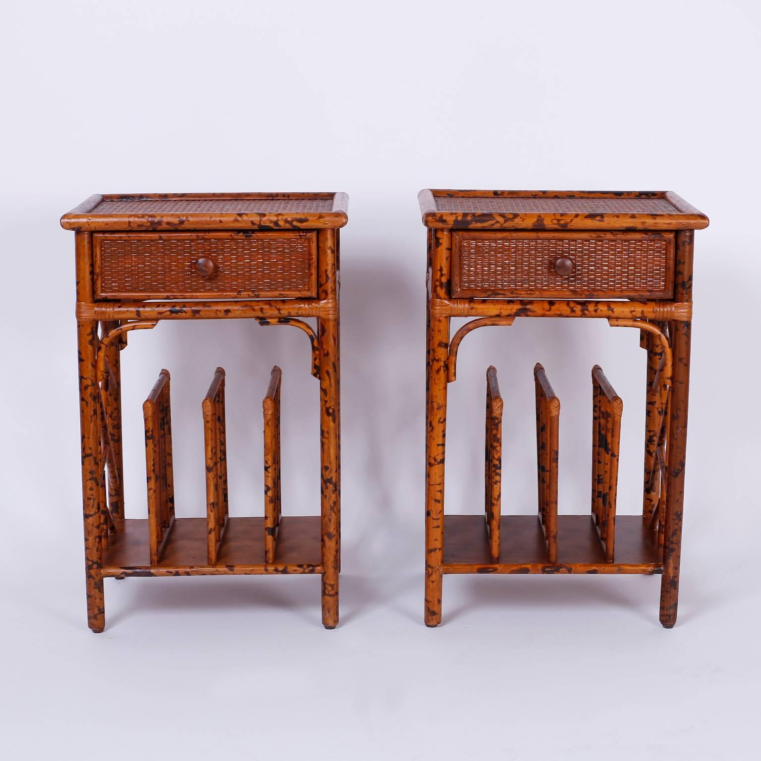Asian inspired one drawer rattan or wicker nightstands or  end tables with a faux tortoiseshell painted bamboo frame, grass cloth panels, Chinese Chippendale style sides and a three sectioned magazine or book rack in the base. East meets west in