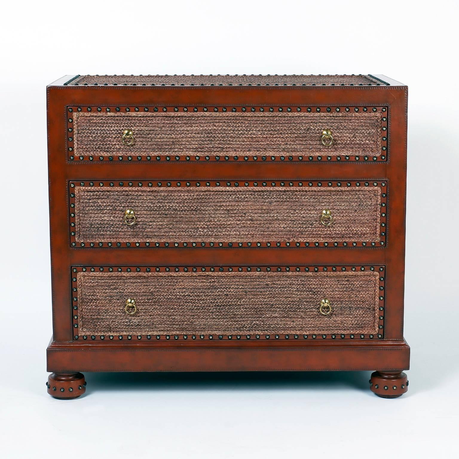 Unconventional three-drawer chest composed with the welcome combination of tooled brown leather, rope, and studs that together make a rather handsome and rugged look. Signed in a drawer Maitland-Smith.
  