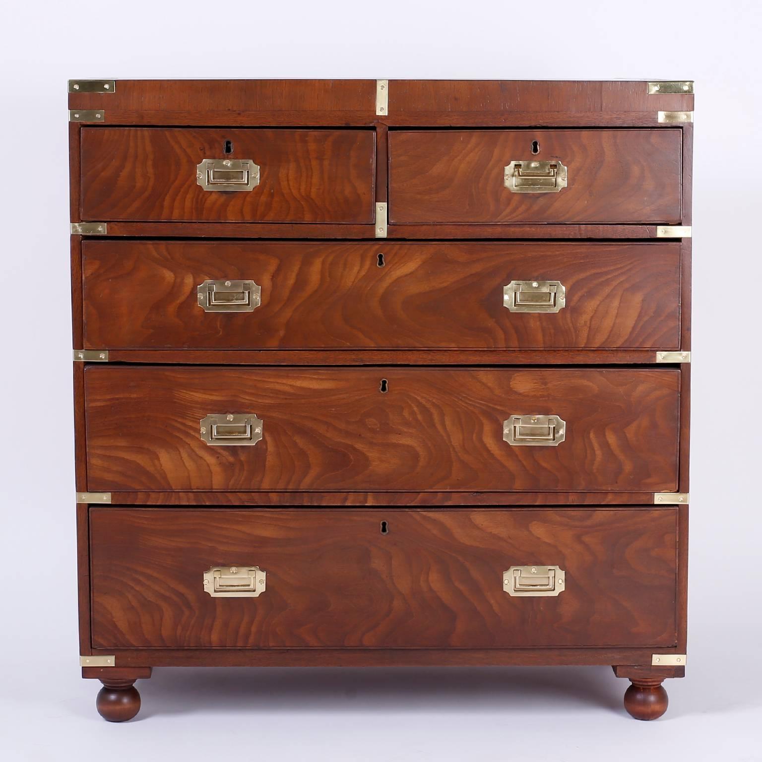 Handsome and historically significant Campaign chest of drawers crafted with exotic grained tropical mahogany on the front. The Classic Campaign protective hardware is hand polished brass and the chest is on ball feet. The back of the case was lined