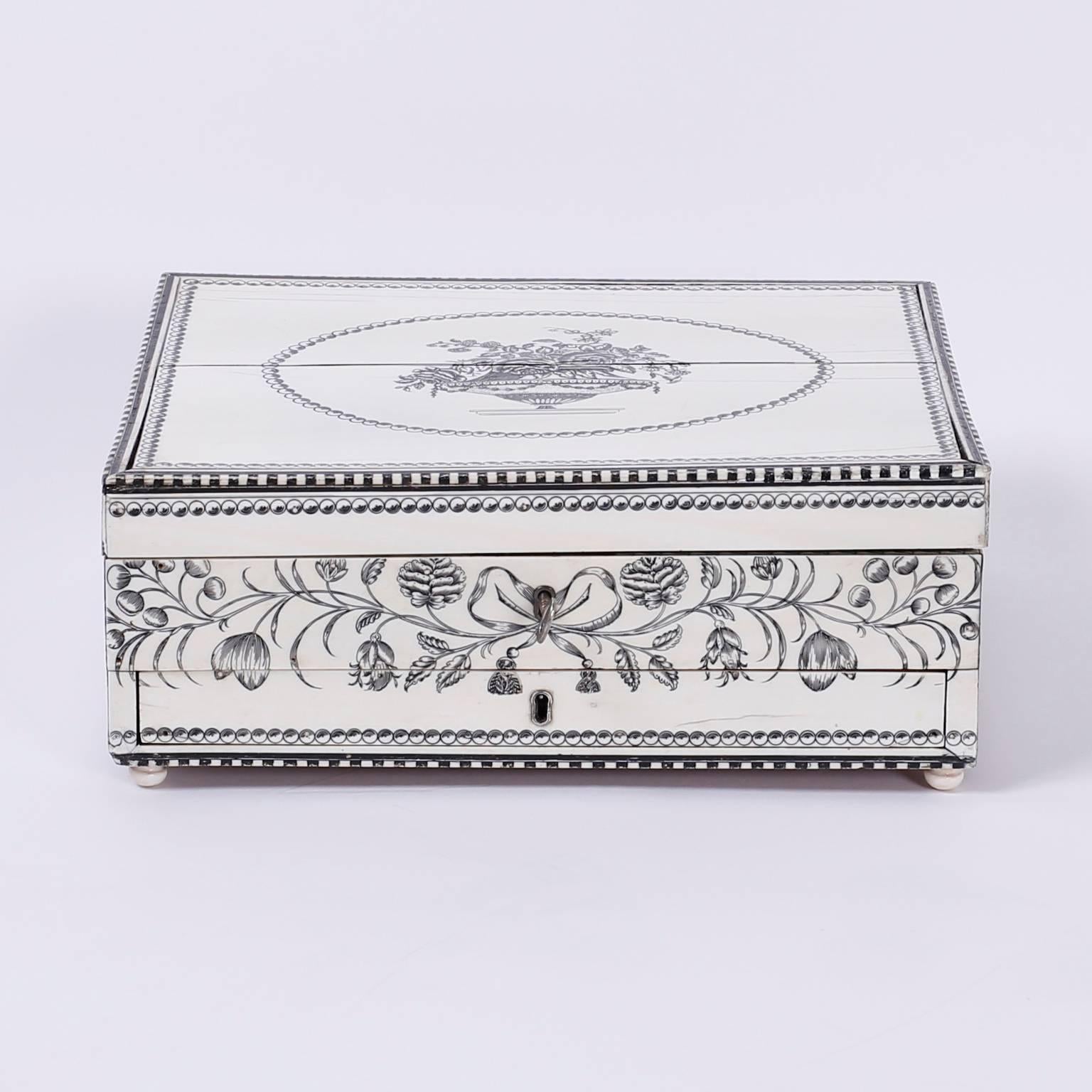 Antique, Anglo Indian sewing box crafted on the outside of the case with bone, meticulously engraved with floral designs and bordered with inlaid ebony. The inside of the box is lined with mahogany and has extensive engraved bone work. Small hidden