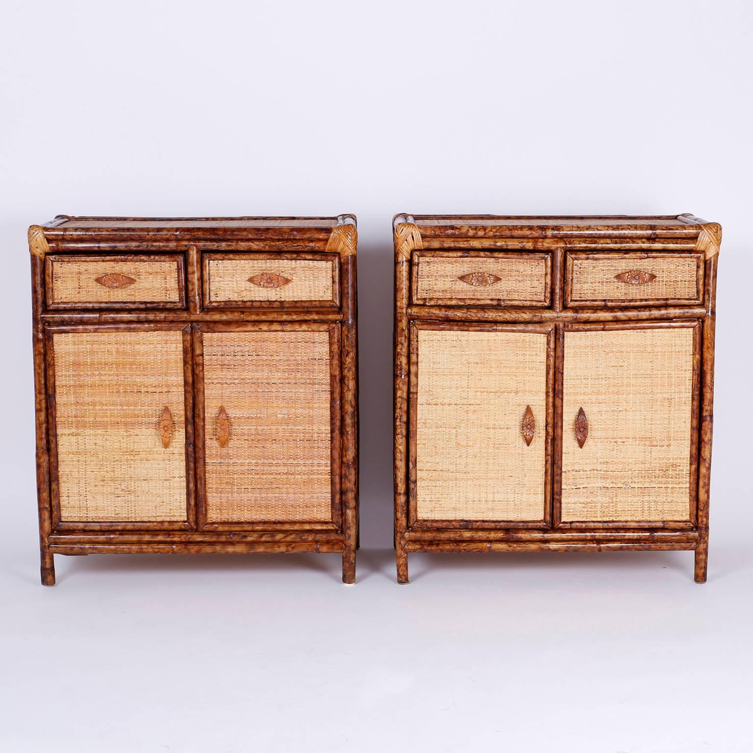 Stand out pair of cabinets or stands with two drawers and two doors with carved wood floral handles. Featuring a custom faux bamboo finish, wrapped corners, and soothing organic colors and textures.