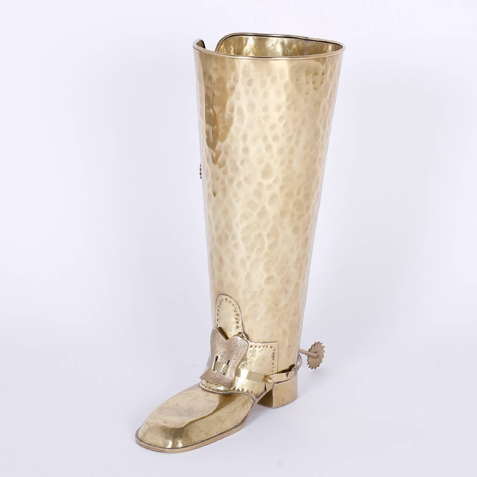 Whimsical umbrella stand crafted in the midcentury with brass featuring laces, buckles, and spurs hand hammered and looking a lot like a conquistador's boot.
