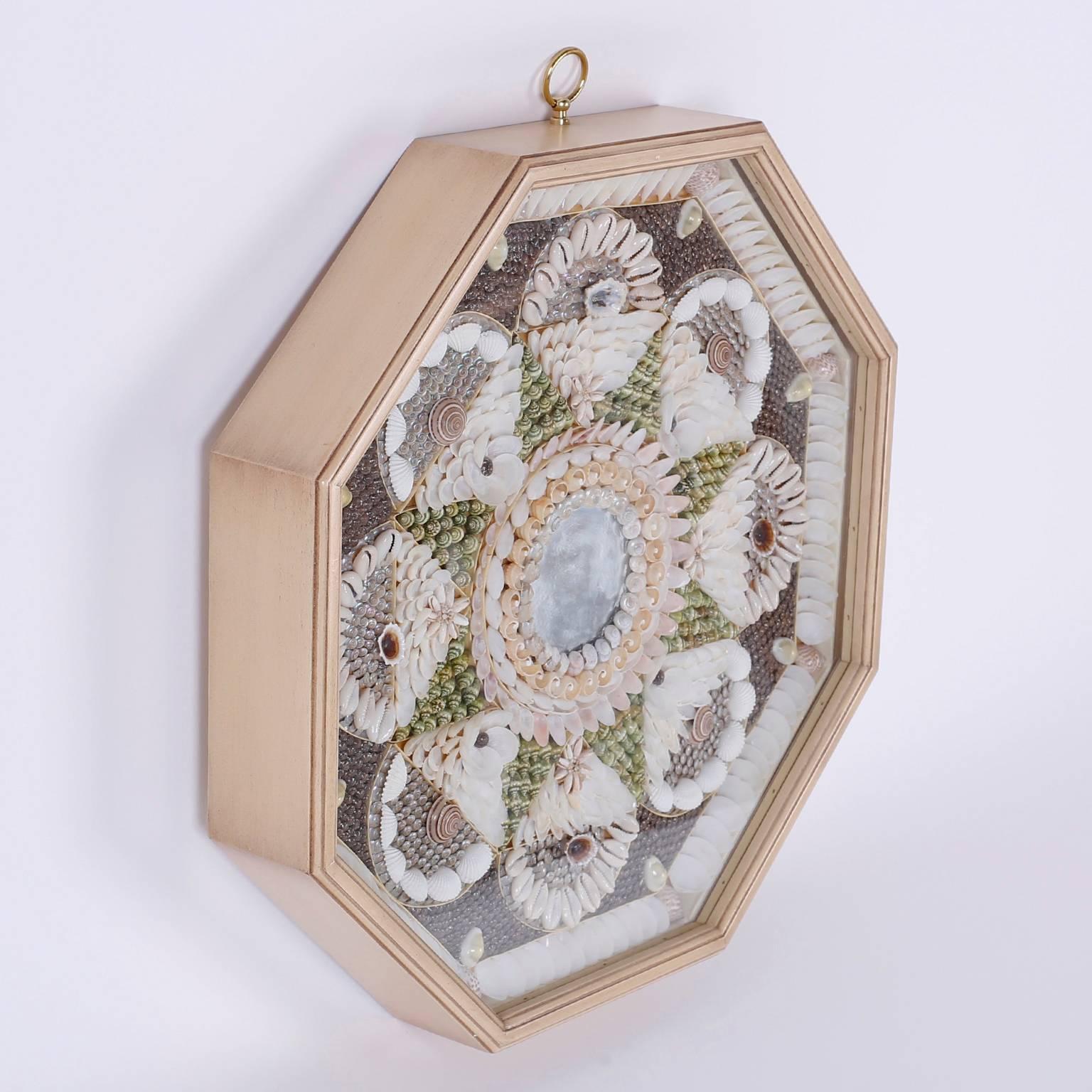 Soothing, sea inspired sailors valentine with organic colors displayed in a tight geometric composition. Presented in an octagon shaped wood frame.