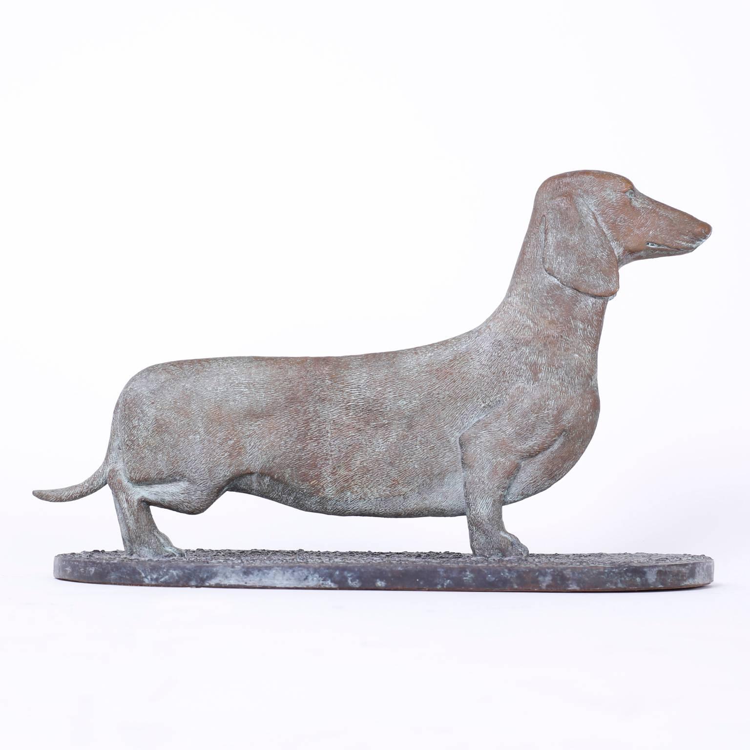 Handsome Mid-Century cast bronze dachshund dog sculpture with stylized vertigree patina over an alert, proud stance. Signed on the bottom Maitland-Smith.